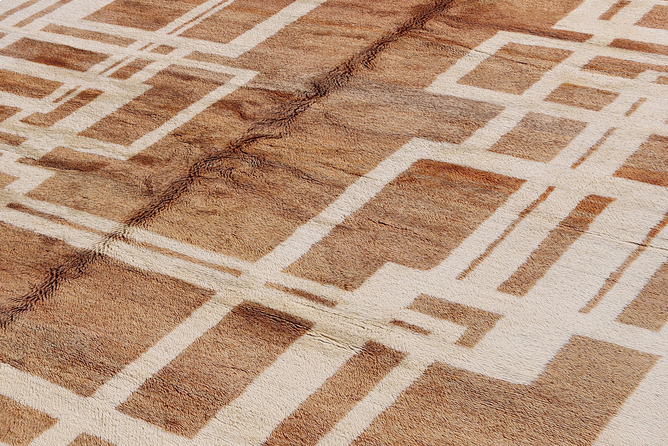 Questo straordinario tappeto marocchino presenta un'audace interazione di geometrie e texture, annodato a mano da abili artigiani con lana naturale nei caldi toni della terra. Il suo motivo quadrato a strati crea profondità visiva e un senso di