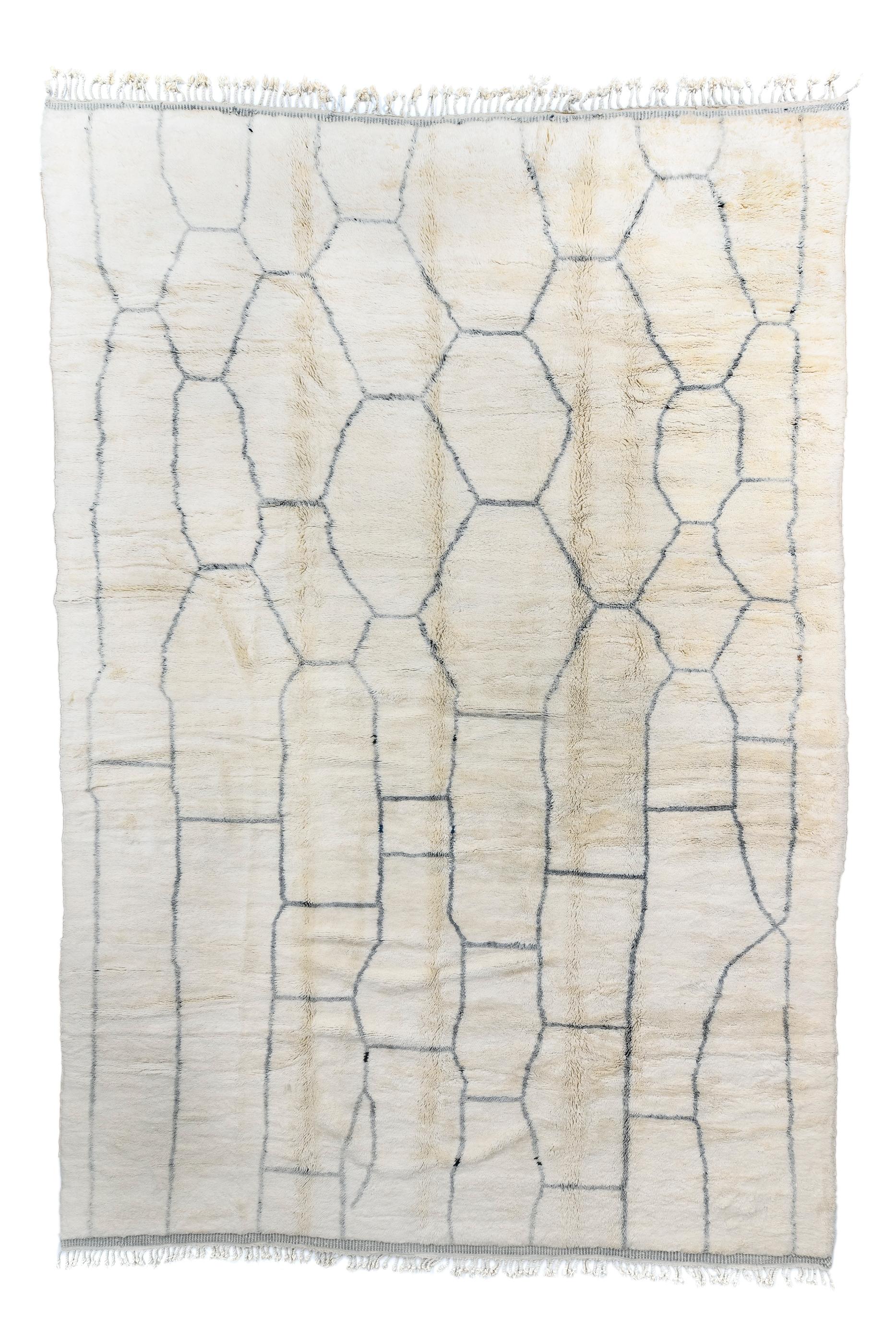 The very irregular, slender slate-charcoal lattice creates ecru reserves in long rough rectangles, stretched ovals and irregular hexagons. The side borders are casual and very in width, and the design flows freely to the ends with no constraining