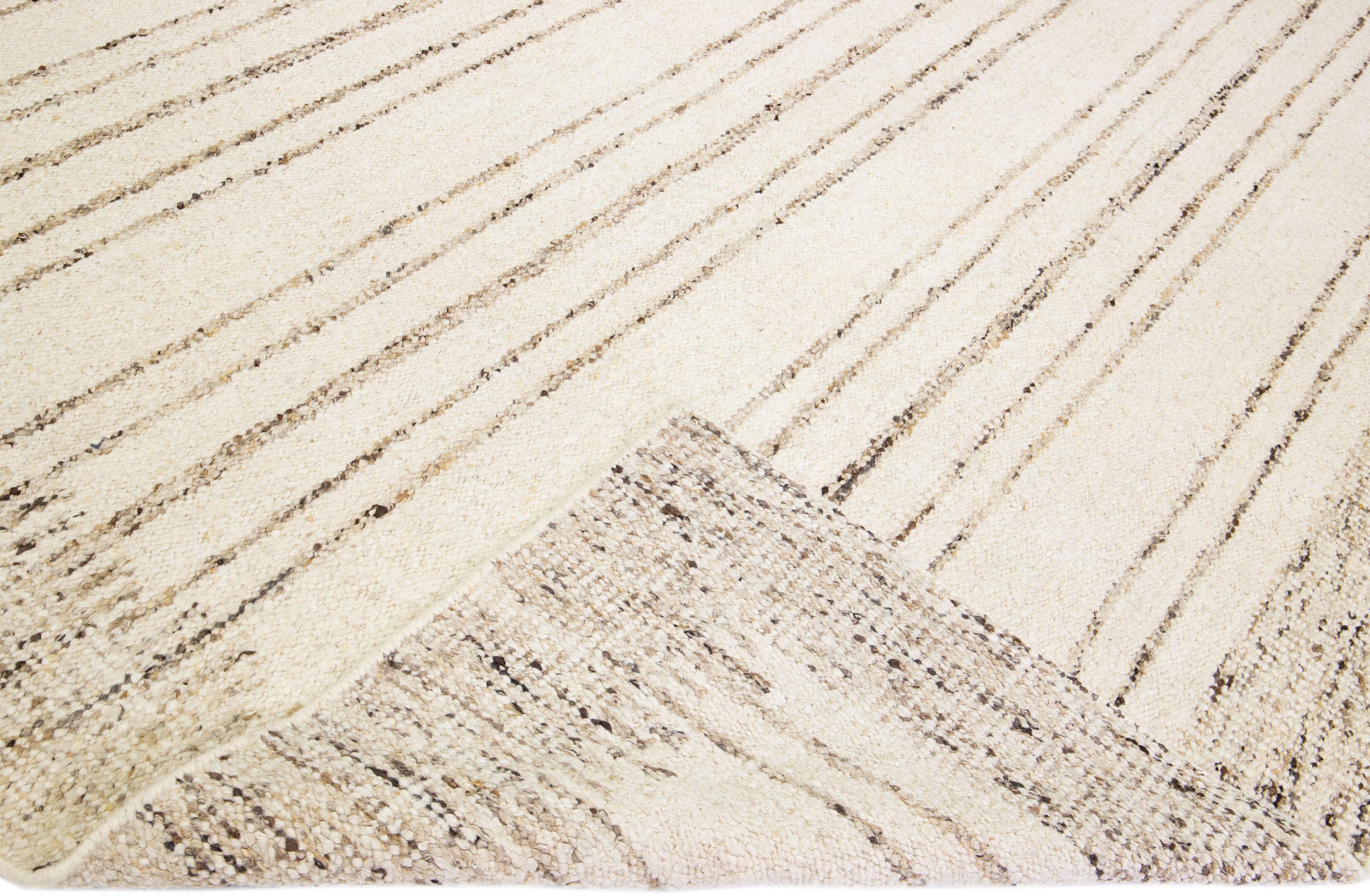 Beautiful modern Moroccan style hand-knotted wool rug with a beige field. This piece has designed frame and brown accent colors in a gorgeous stripe design.

This rug measures: 12' x 15'

Our rugs are professional cleaning before shipping.