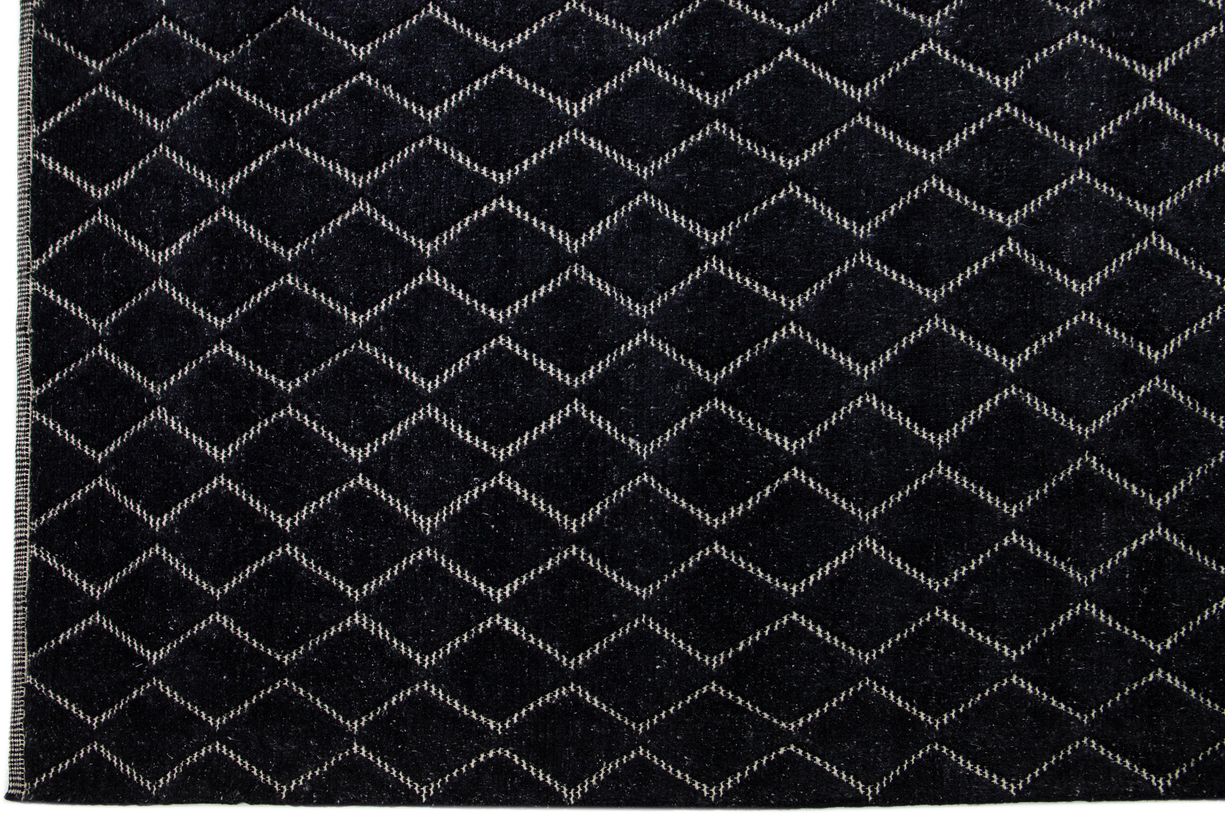 Introducing a contemporary Moroccan rug with a lavish allover geometric design intricately hand-knotted against a backdrop of elegant black.

This rug measures 10'3