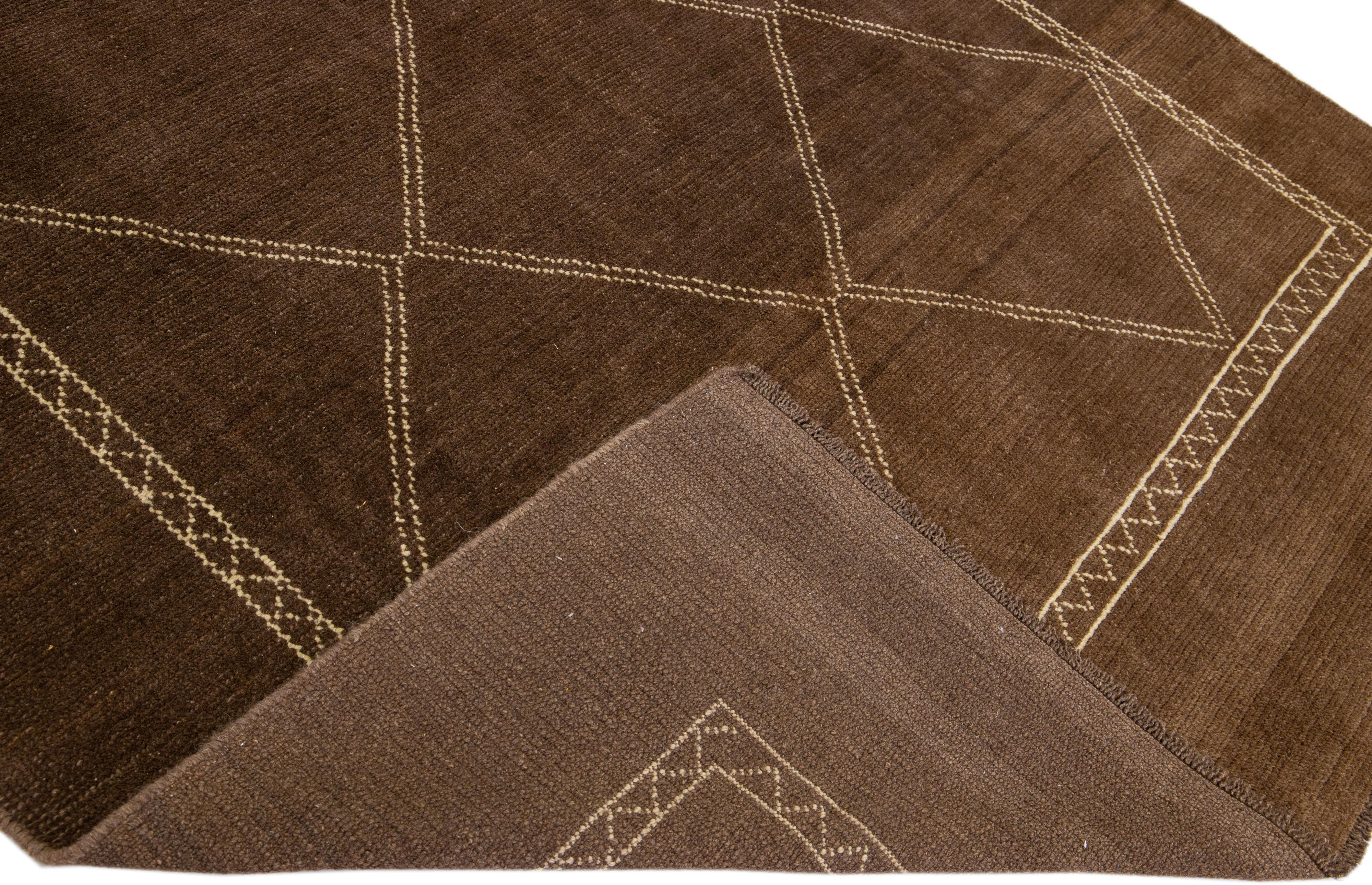 This Beautiful Moroccan-style handmade wool rug makes part of our Northwest collection and features a brown color field and beige accents in a gorgeous geometric tribal design.

This rug measures: 6'10