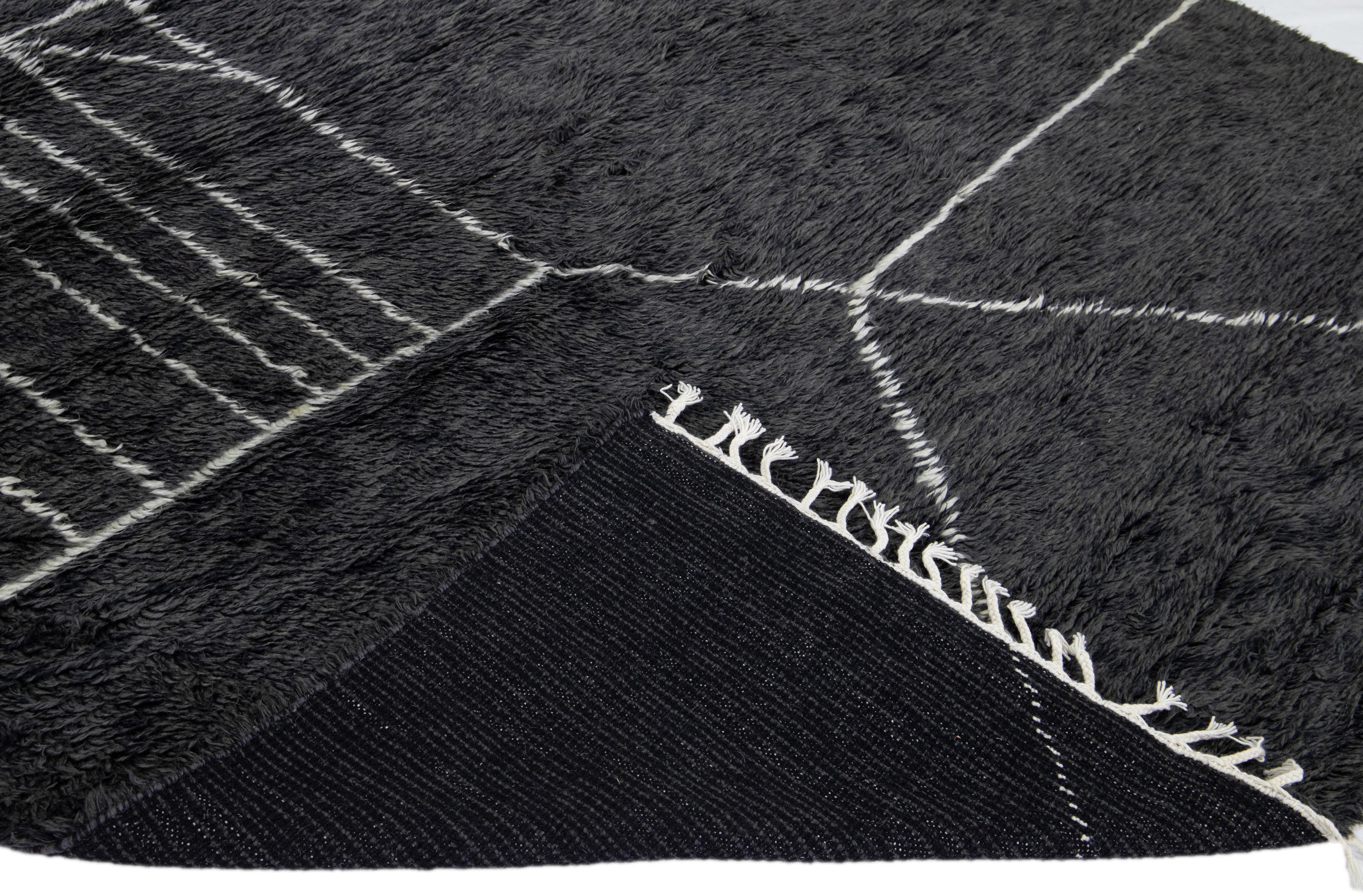 Beautiful modern Moroccan style hand-knotted wool rug with a black field and white fringes in a gorgeous geometric abstract high pile design.

This rug measures: 9'4'' x 12'.

Our rugs are professional cleaning before shipping.