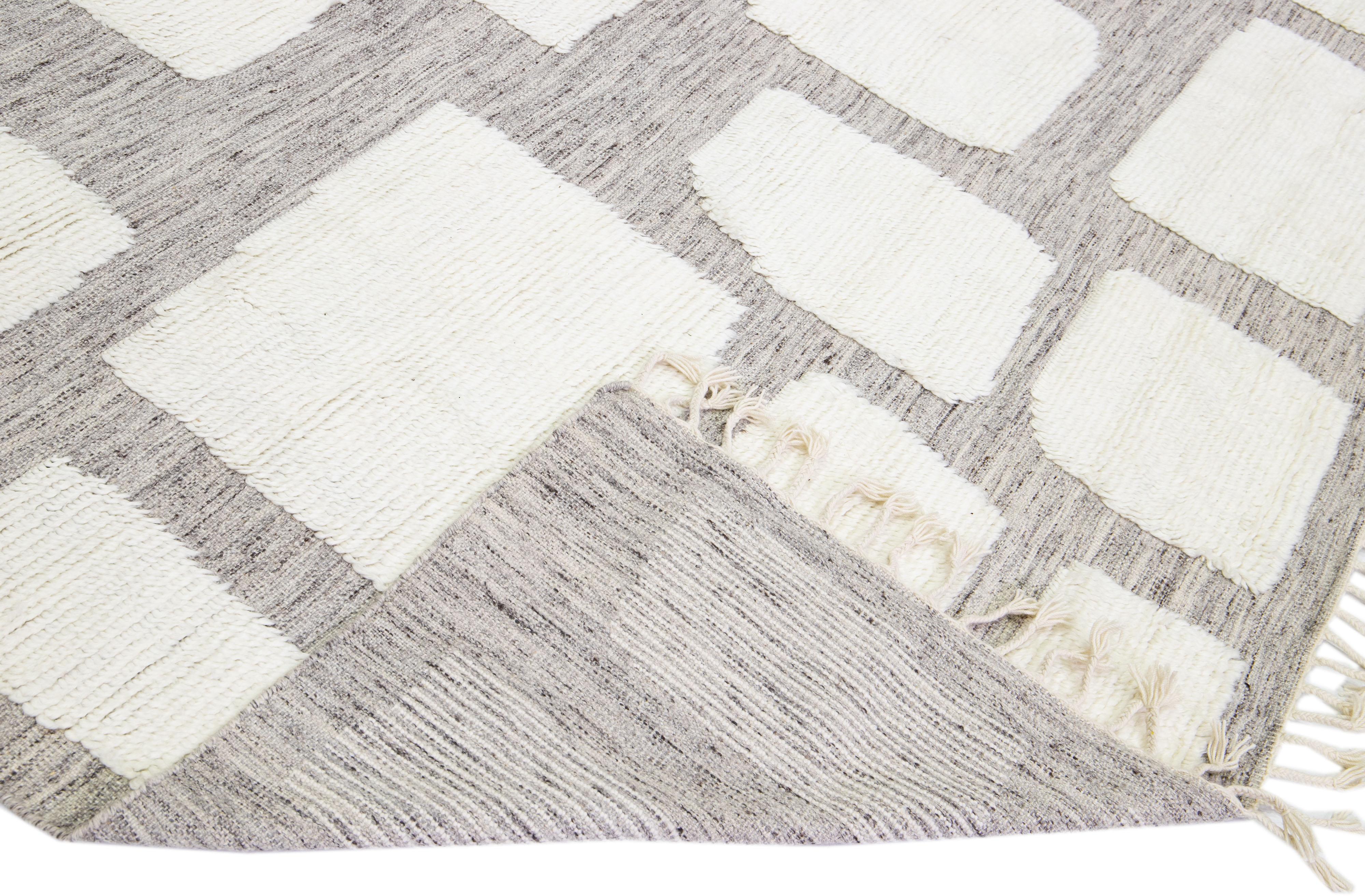 Beautiful modern Moroccan style hand-knotted wool rug with a light gray field and ivory accents in a gorgeous geometric high pile design.

This rug measures: 12' x 14'11