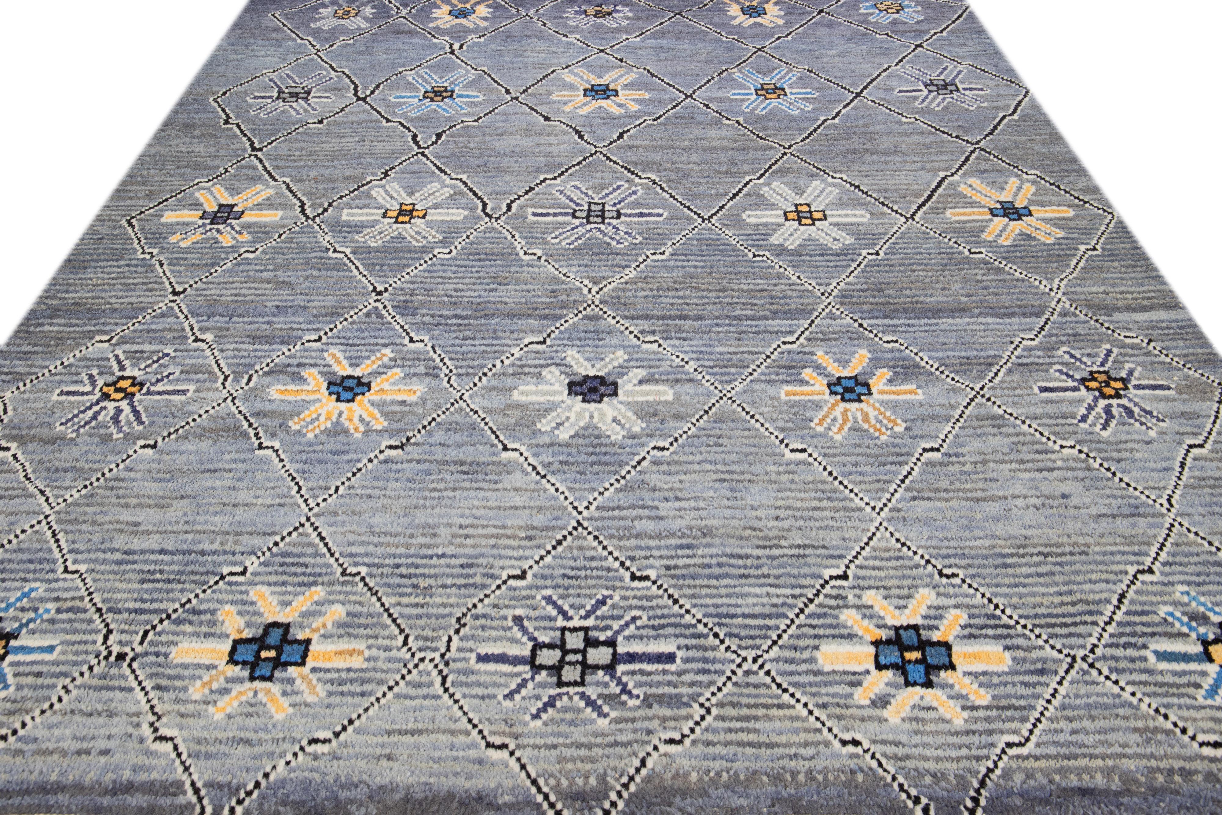 Beautiful modern Moroccan-style hand-knotted wool rug with a gray field. This piece has orange, blue, black, and white accent colors in a gorgeous tribal design with fringes on the top and bottom end.

This rug measures: 8'3
