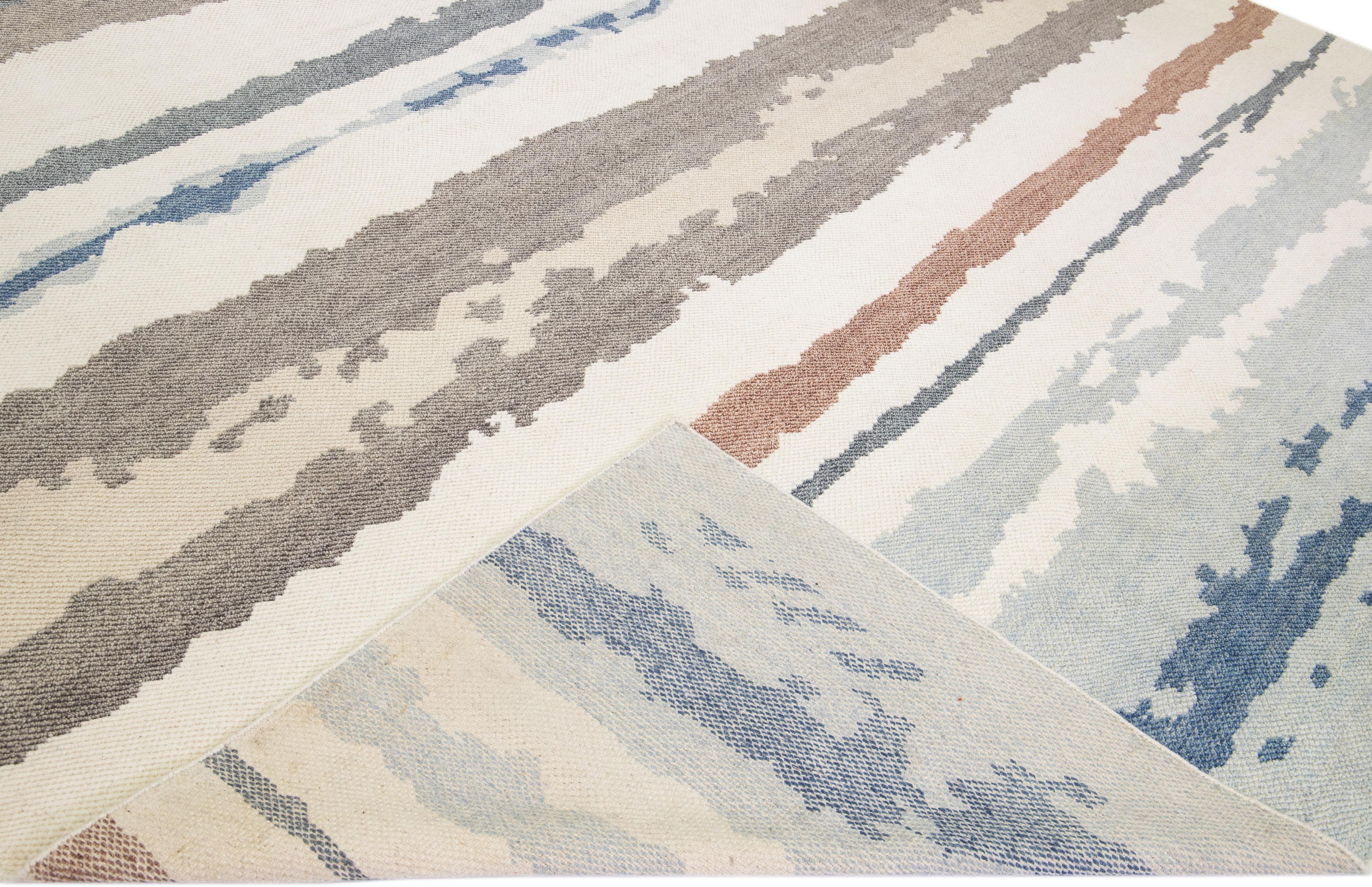 Beautiful Moroccan style handmade wool rug with an Ivory field. This Modern rug has earthy tone accents featuring a gorgeous abstract design.

This rug measures: 11'10