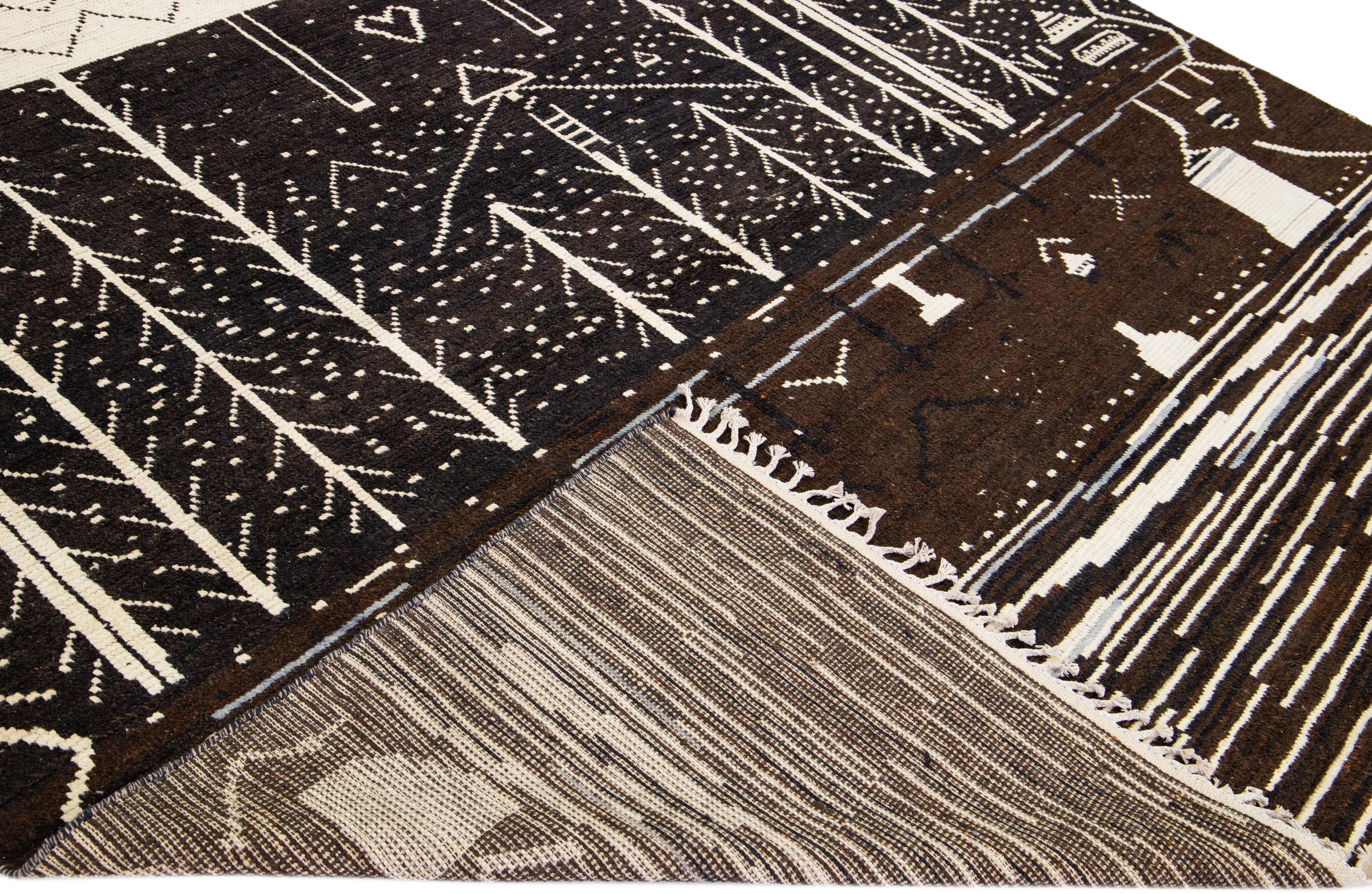 Beautiful modern Moroccan style hand-knotted wool rug with a brown field. This piece has beige accent color in a gorgeous tribal design with fringes on the top and bottom end.

This rug measures: 10'1
