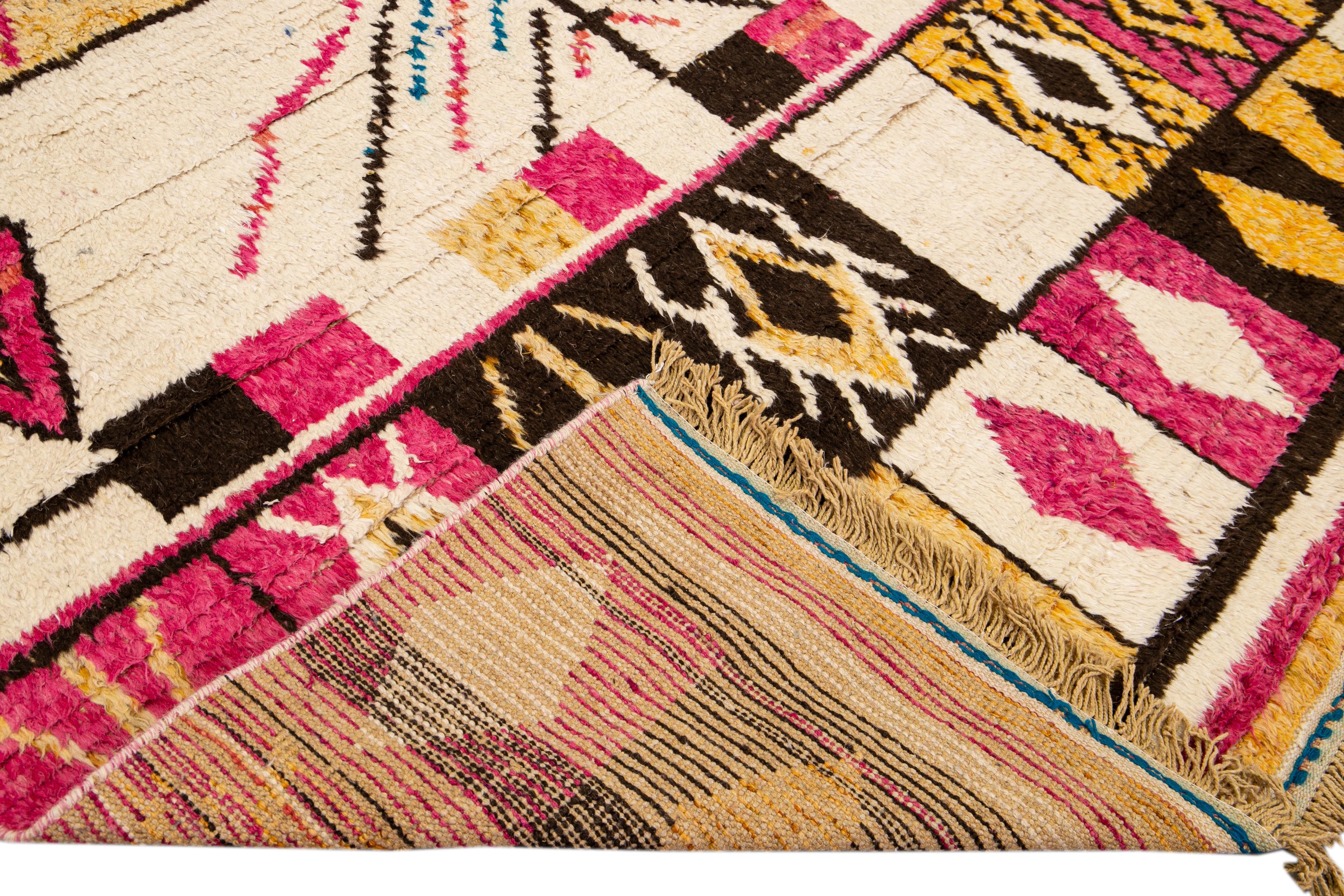 Beautiful Moroccan style handmade wool rug with a beige field. This Modern rug has pink, brown, blue, yellow accents and tan fringes featuring a gorgeous all-over geometric boho tribal design.

This rug measures: 8' x 10'4