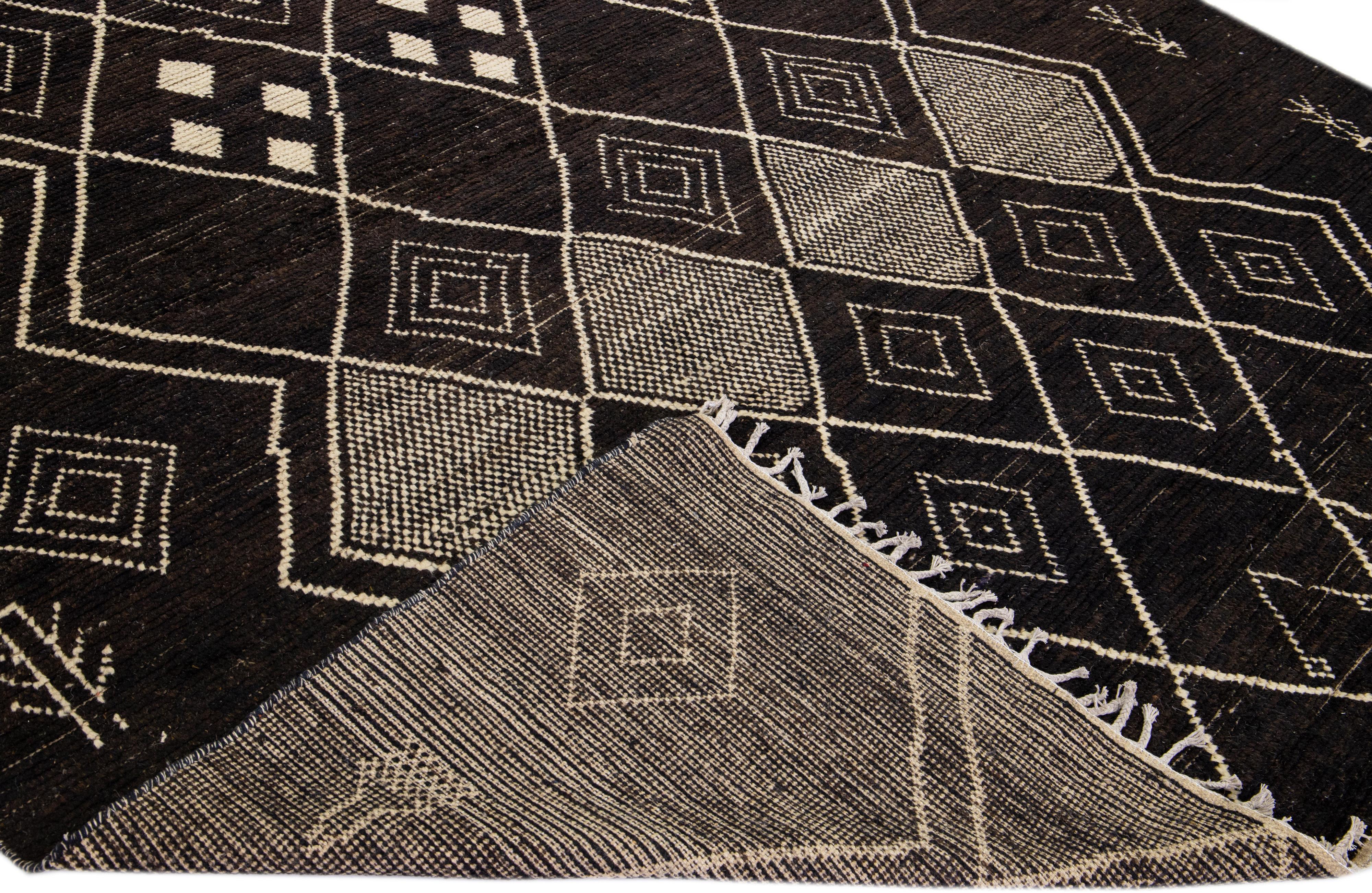 Beautiful modern Moroccan style hand-knotted wool rug with a brown field. This piece has beige accent color in a gorgeous tribal design with fringes on the top and bottom end.

This rug measures: 8'10