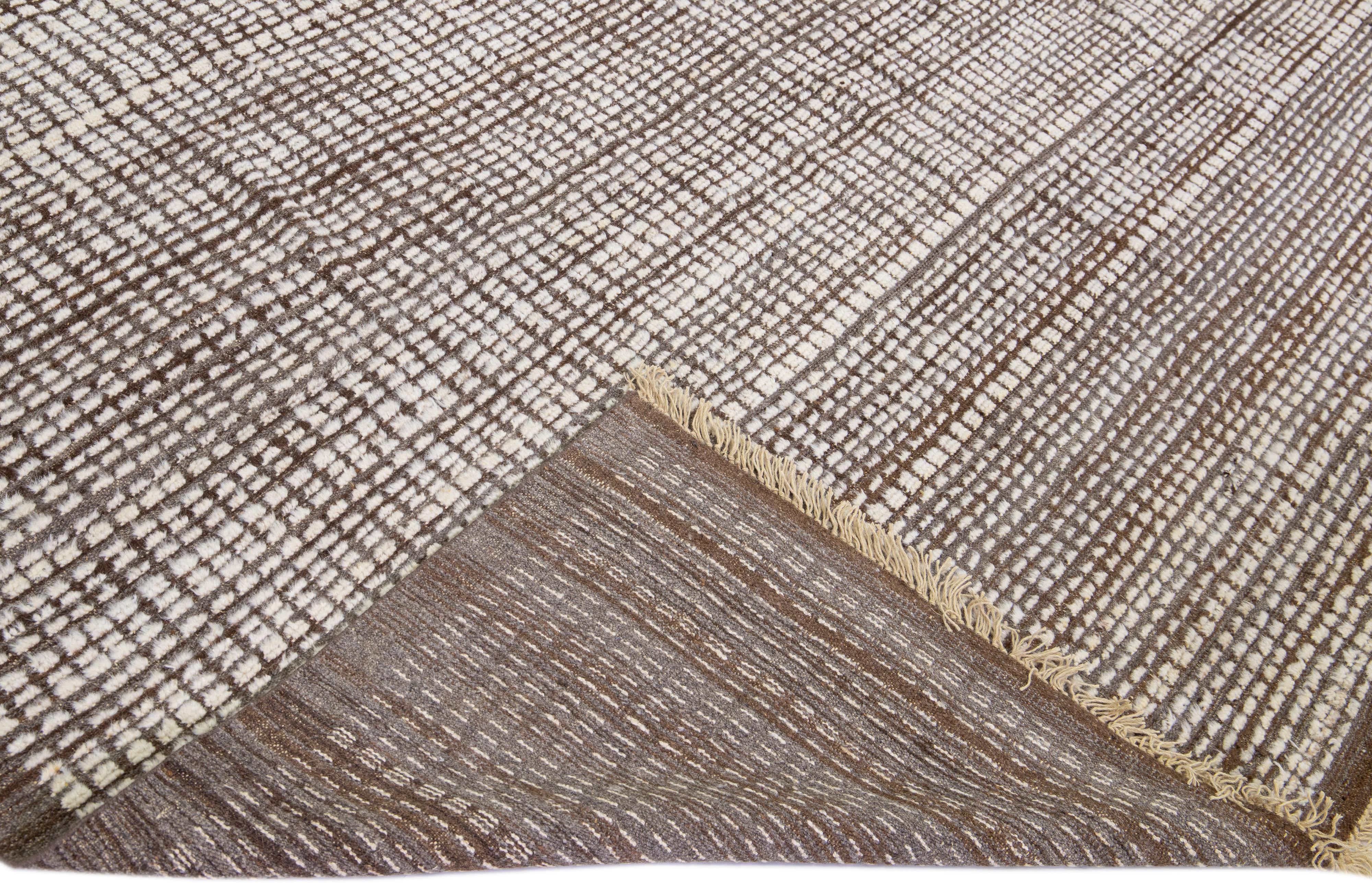 Beautiful modern Moroccan style hand-knotted wool rug with a brown field. This piece has a gorgeous subtle geometric pattern design.

This rug measures: 10'9