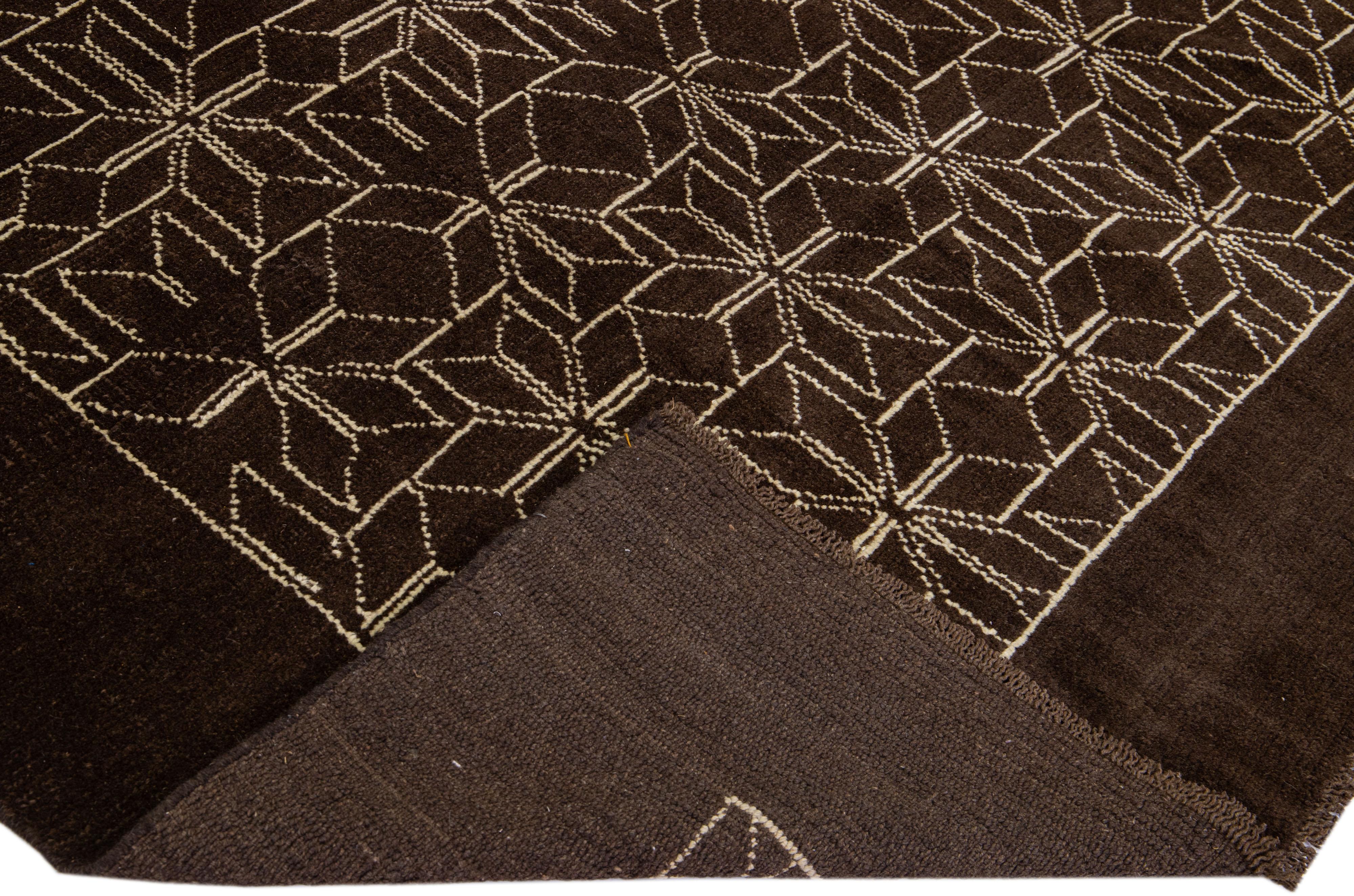 This Beautiful Moroccan-style handmade wool rug makes part of our Northwest collection and features a dark brown color field and beige accents in a gorgeous geometric tribal design.

This rug measures: 7' x 9'2