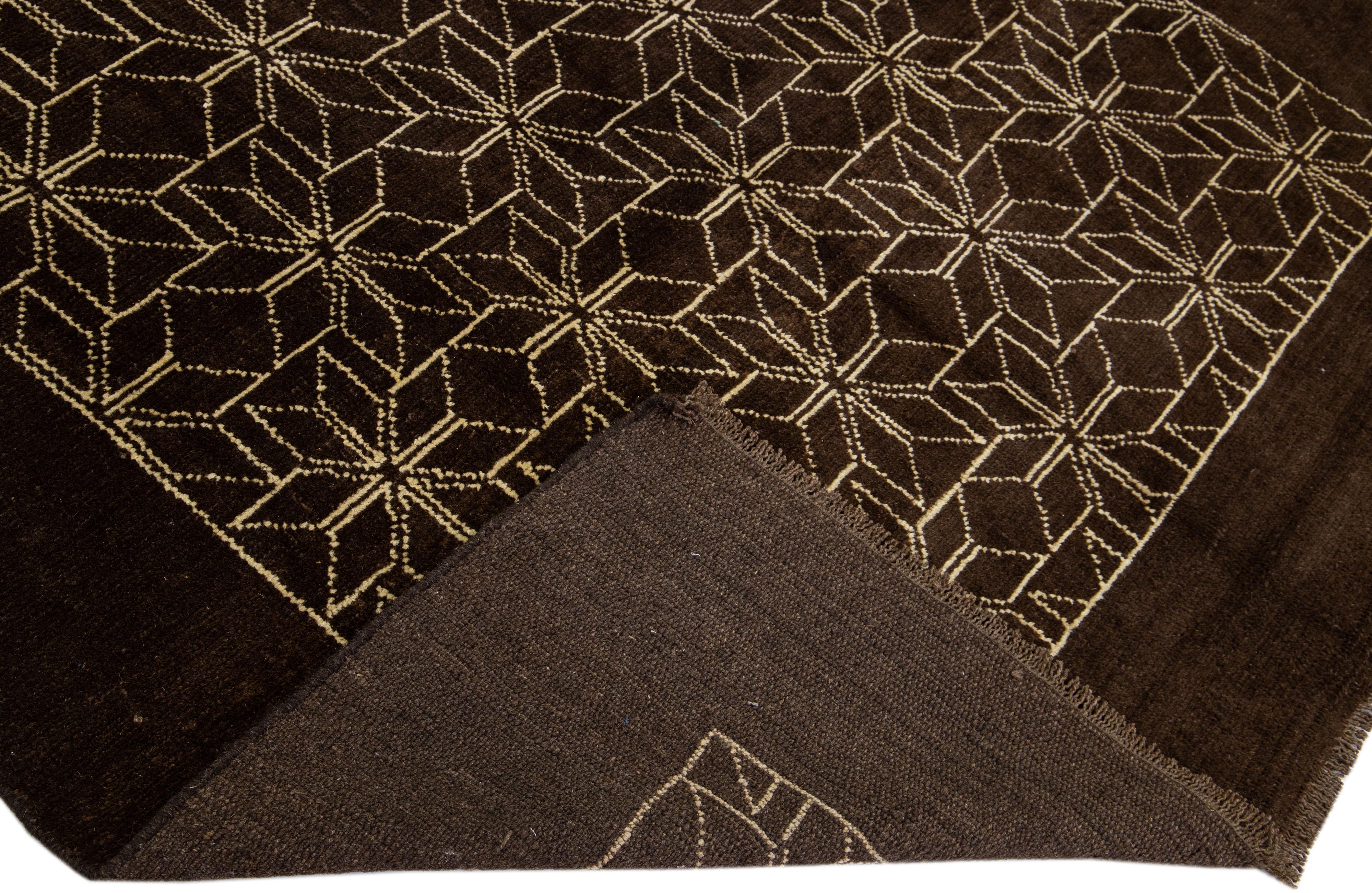 This Beautiful Moroccan-style handmade wool rug makes part of our Northwest collection and features a dark brown color field and beige accents in a gorgeous geometric tribal design.

This rug measures: 7' x 8'11