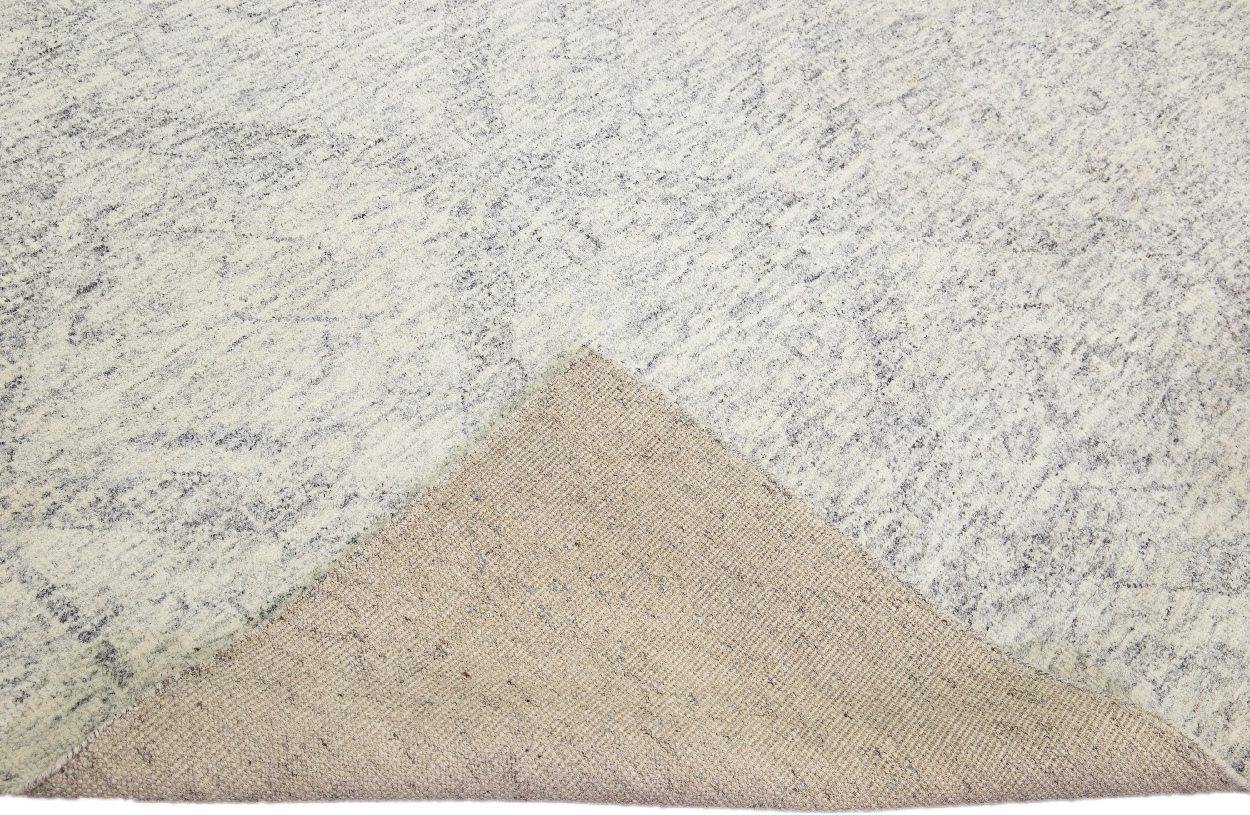 Magnifique tapis moderne de style marocain en laine nouée à la main avec un champ ivoire. Ce tapis de la collection Safi d'Apadana présente des accents gris dans un magnifique motif de treillis géométrique.

Ce tapis mesure : 8'11
