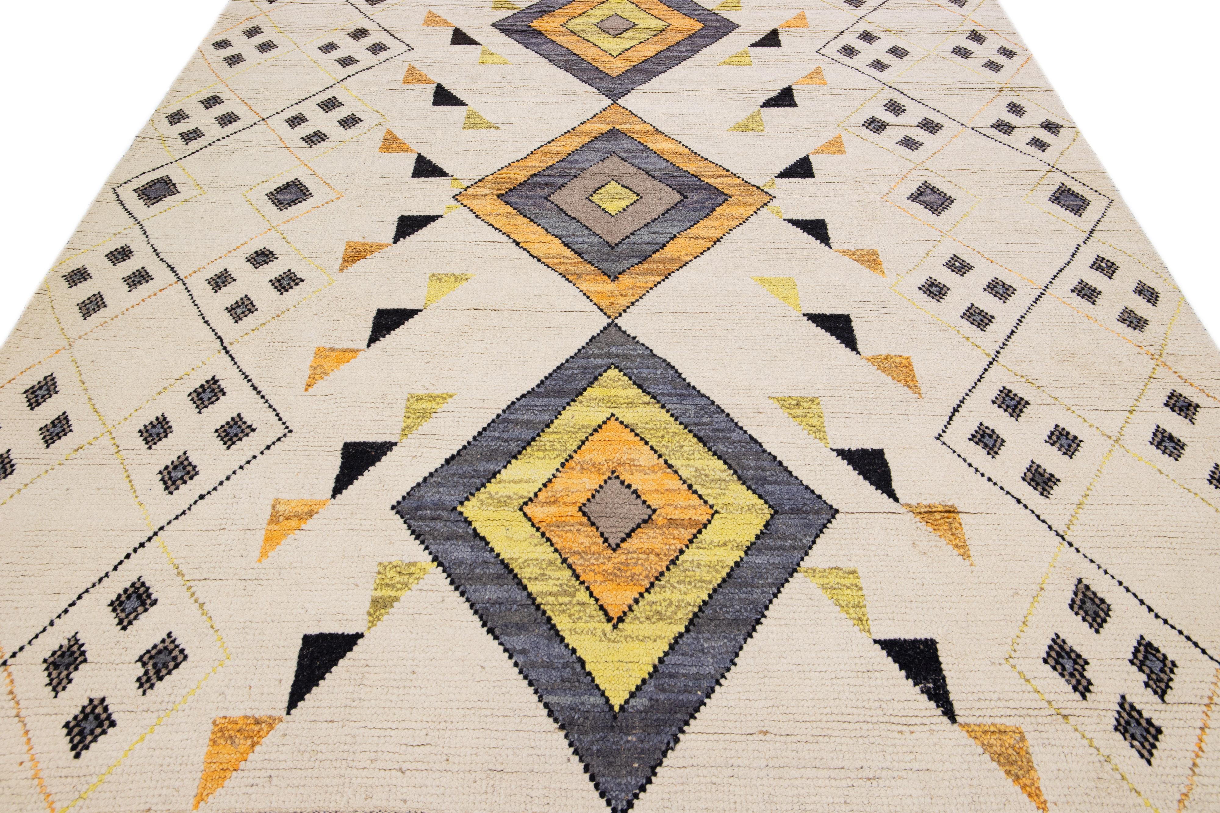 Beautiful modern Moroccan-style hand-knotted wool rug with a beige field. This piece has orange, gray, and yellow accent colors in a gorgeous tribal design.

This rug measures 8' x 10'1