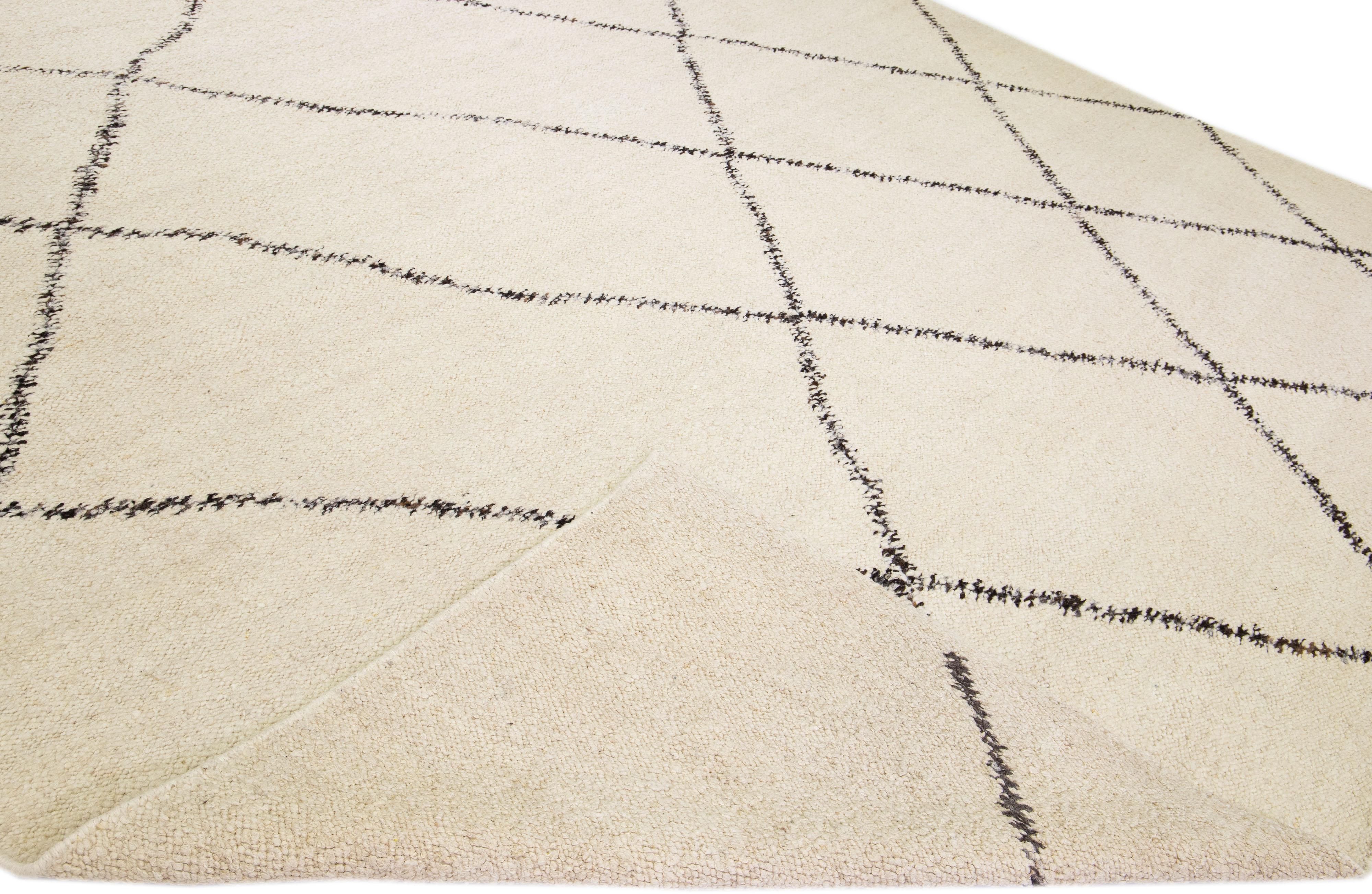 Beautiful modern Moroccan style hand-knotted wool rug with an ivory field. This piece has dark brown accent color in a gorgeous geometric design.

This rug measures: 12' x 15'

Our rugs are professional cleaning before shipping.