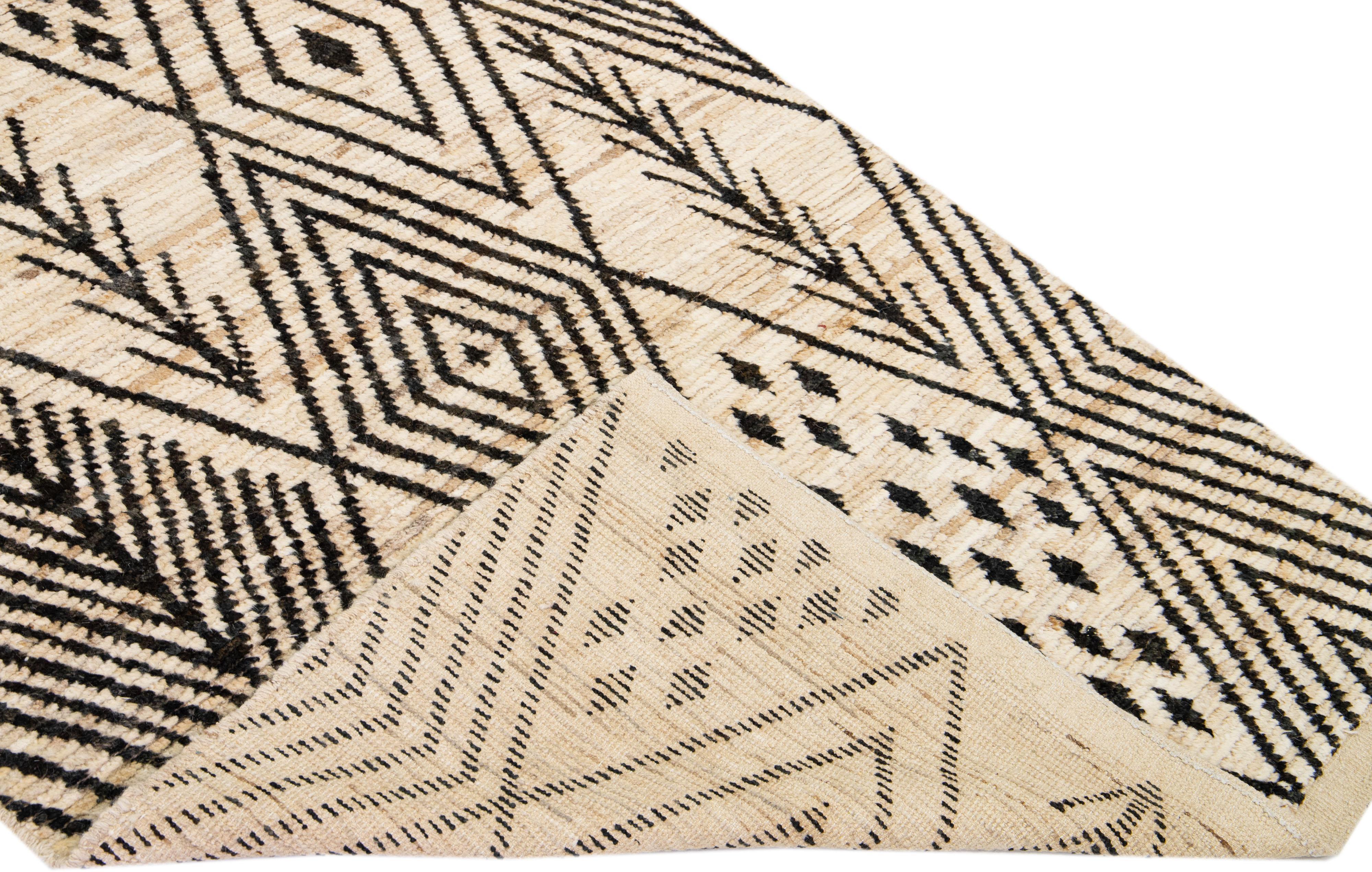 Beautiful Moroccan-style handmade wool rug with a beige field. This Modern rug has dark brown accents featuring a gorgeous all-over geometric tribal design.

This rug measures: 4'5