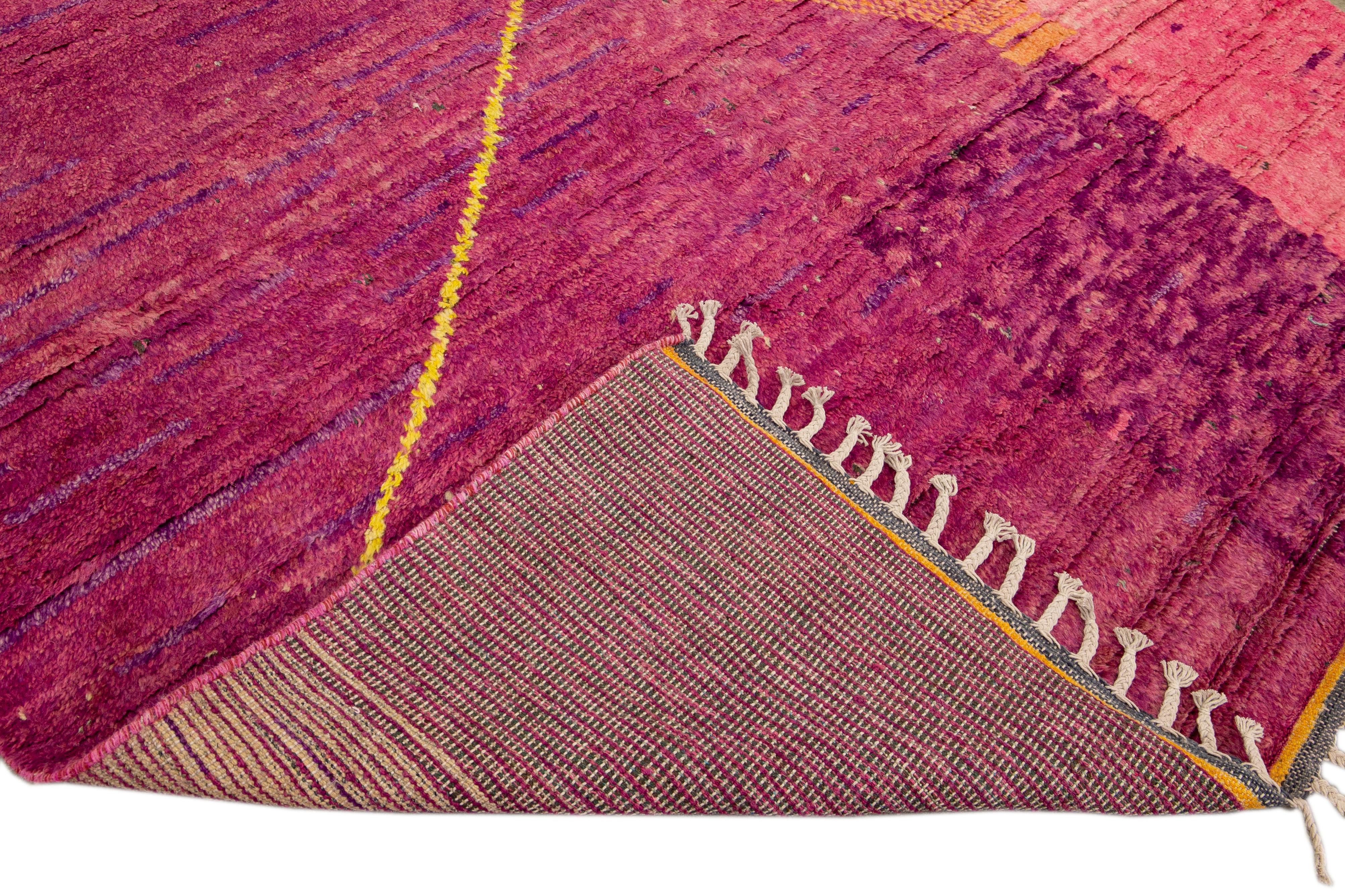 Beautiful Moroccan style handmade wool rug with a purple and pink field. This Modern rug has orange and yellow accents and beige fringes featuring a gorgeous all-over boho minimal design.

This rug measures: 7'8
