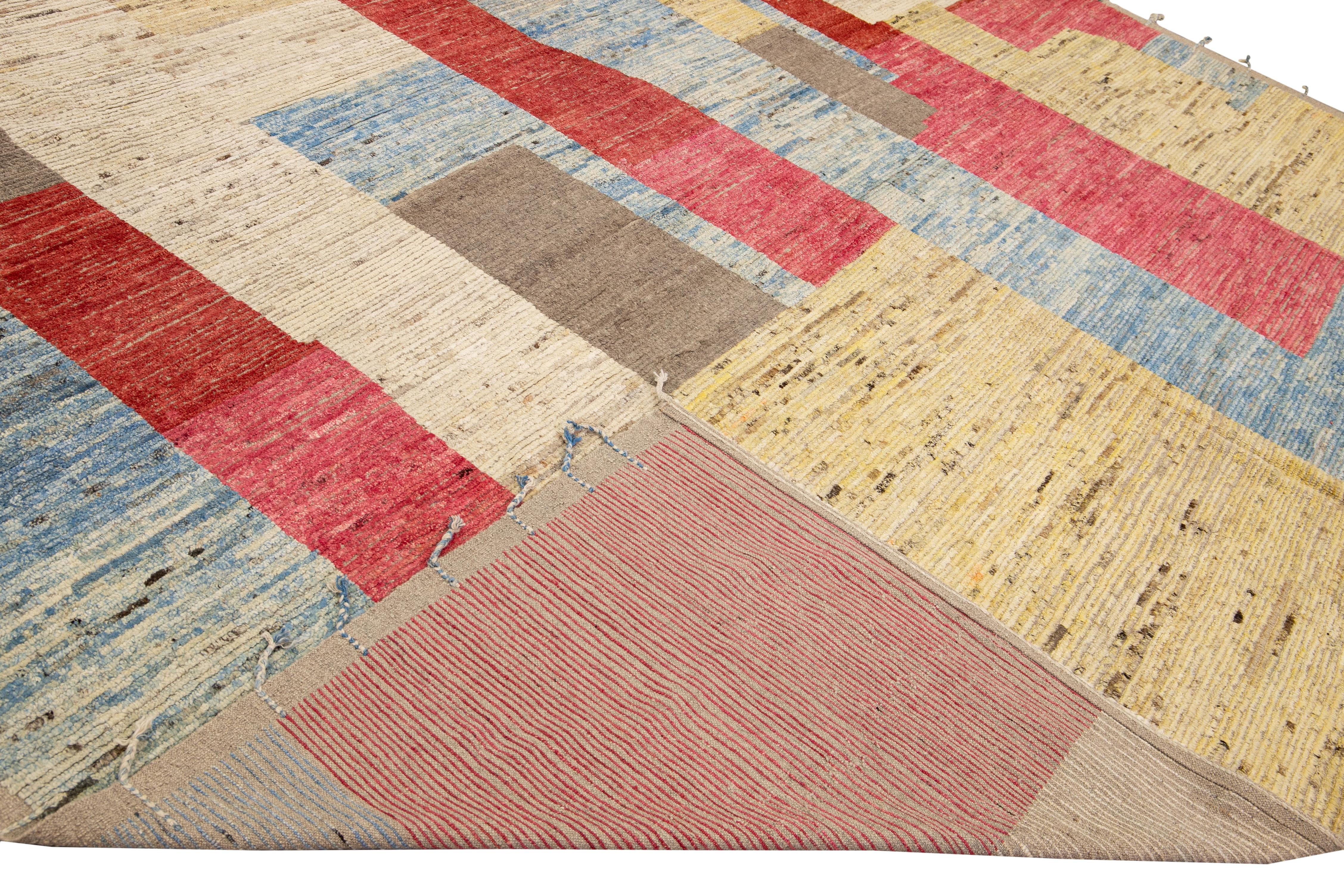 Beautiful Moroccan style handmade wool rug with a beige field. This Modern rug has brown, blue, red, and yellow accents and beige fringes featuring a gorgeous all-over boho minimal design.

This rug measures: 14'4