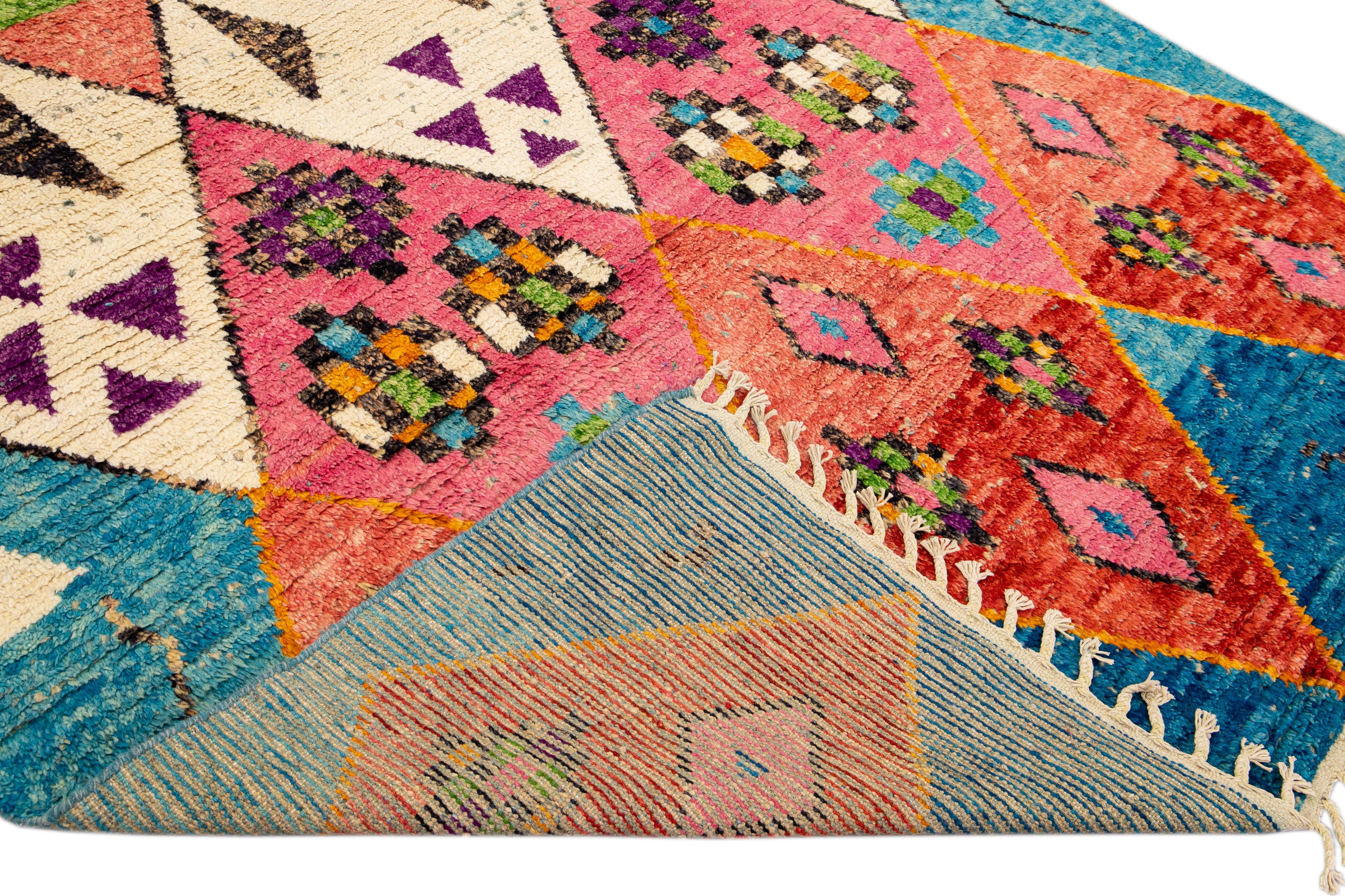Magnifique tapis en laine fait main de style marocain avec un champ bleu. Ce tapis moderne aux accents multicolores et aux franges beiges présente un magnifique motif tribal bohème sur toute sa surface.

Ce tapis mesure : 7'9