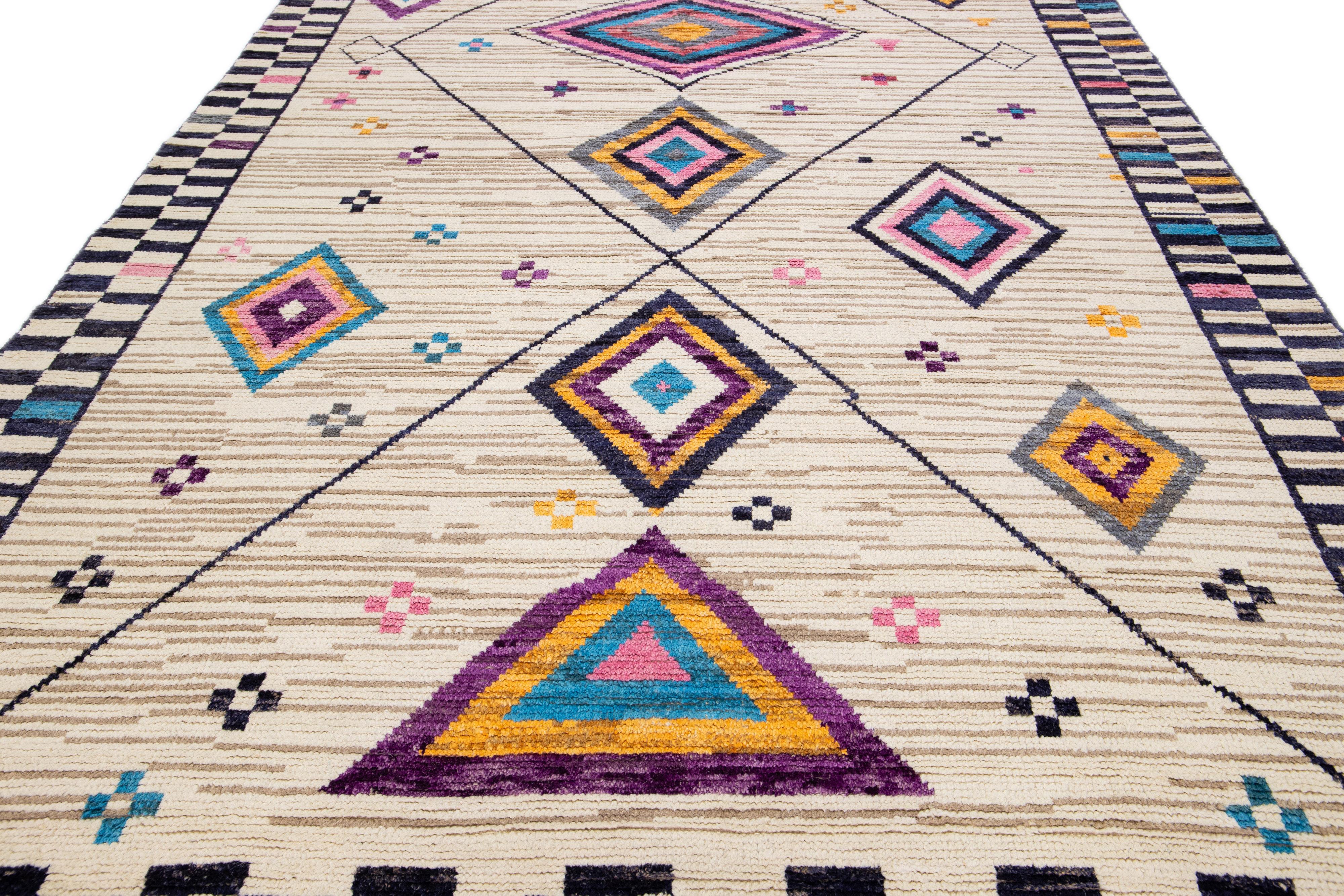 Beautiful modern Moroccan-style hand-knotted wool rug with a beige field. This piece has multicolor accent colors in a gorgeous tribal design with fringes on the top and bottom end.

This rug measures: 8'4