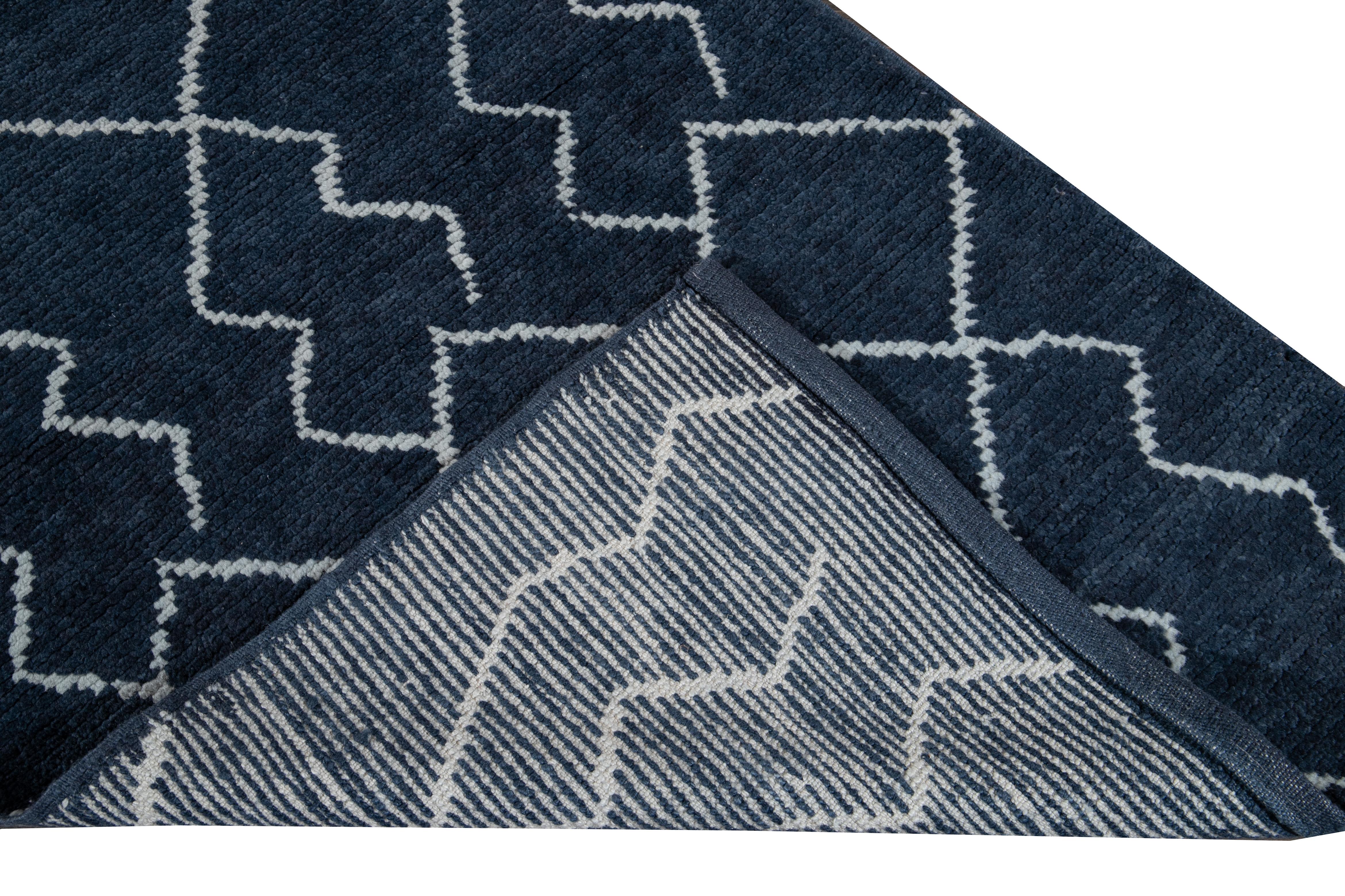 Beautiful contemporary Moroccan style runner hand knotted wool rug with a navy-blue field. This modern rug has an ivory accent in a gorgeous all-over geometric tribal design.

This rug measures: 3'1' x 12'2
