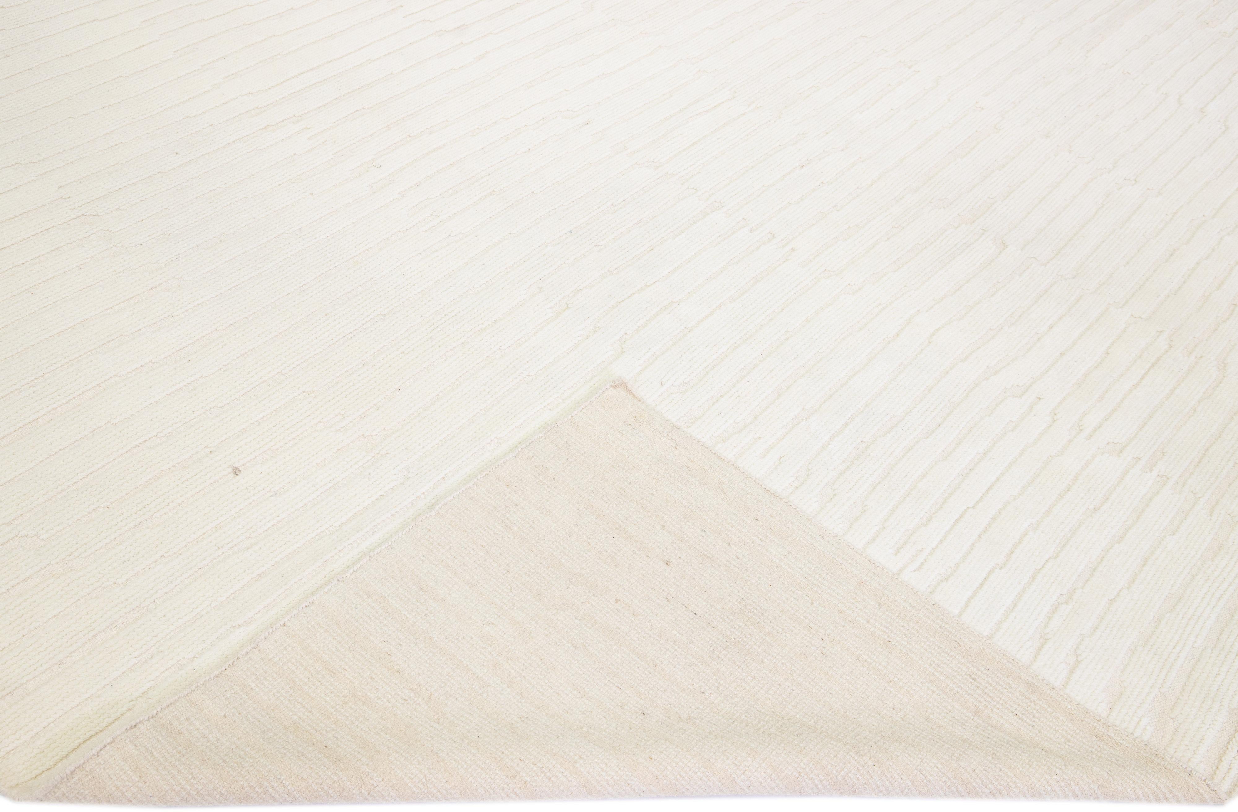 Magnifique tapis moderne en laine nouée à la main de style marocain, avec un champ beige dans un design rayé all-over.

Ce tapis mesure : 12' x 15'3