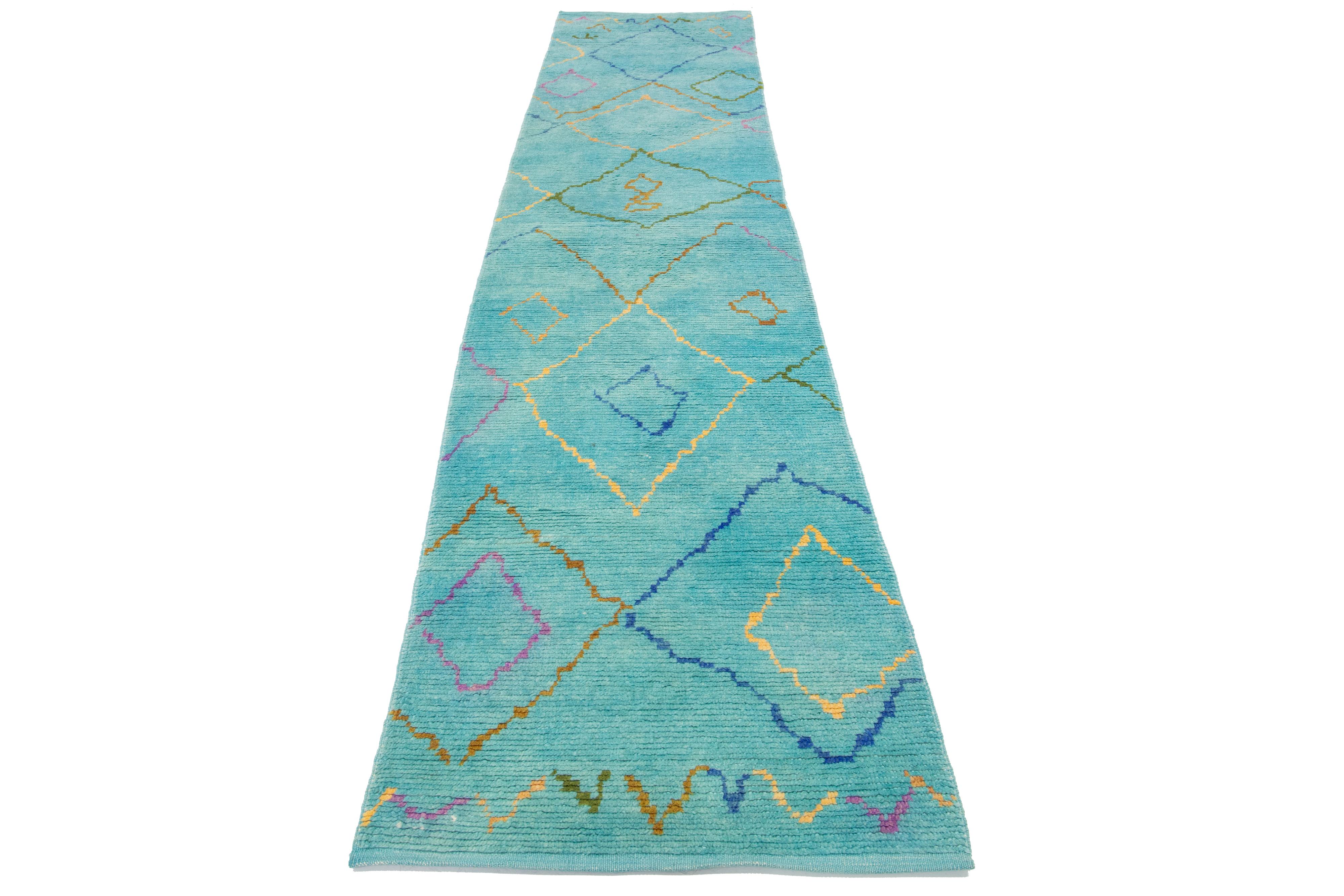 Beautiful Moroccan-style handmade wool rug with a teal field. This Modern rug has multicolor accents featuring a gorgeous all-over geometric tribal design.

This rug measures 3' x 14'.

Our rugs are professionally cleaned before shipping.
