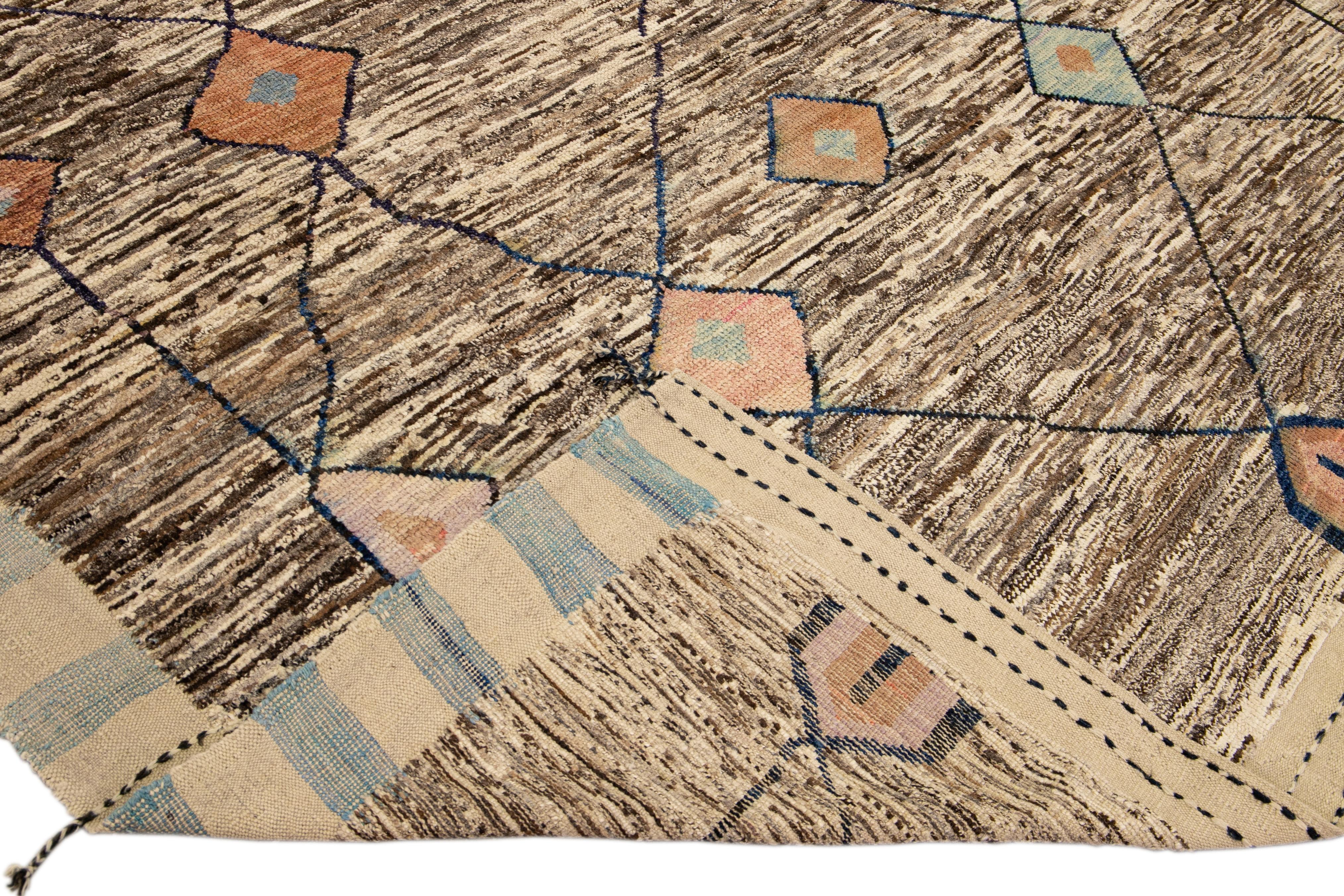 Beautiful Moroccan style handmade wool rug with a beige and brown field. This Modern rug has orange, pink, and blue accents and beige-blue braid fringes featuring a gorgeous all-over tribal boho design.

This rug measures: 8'10