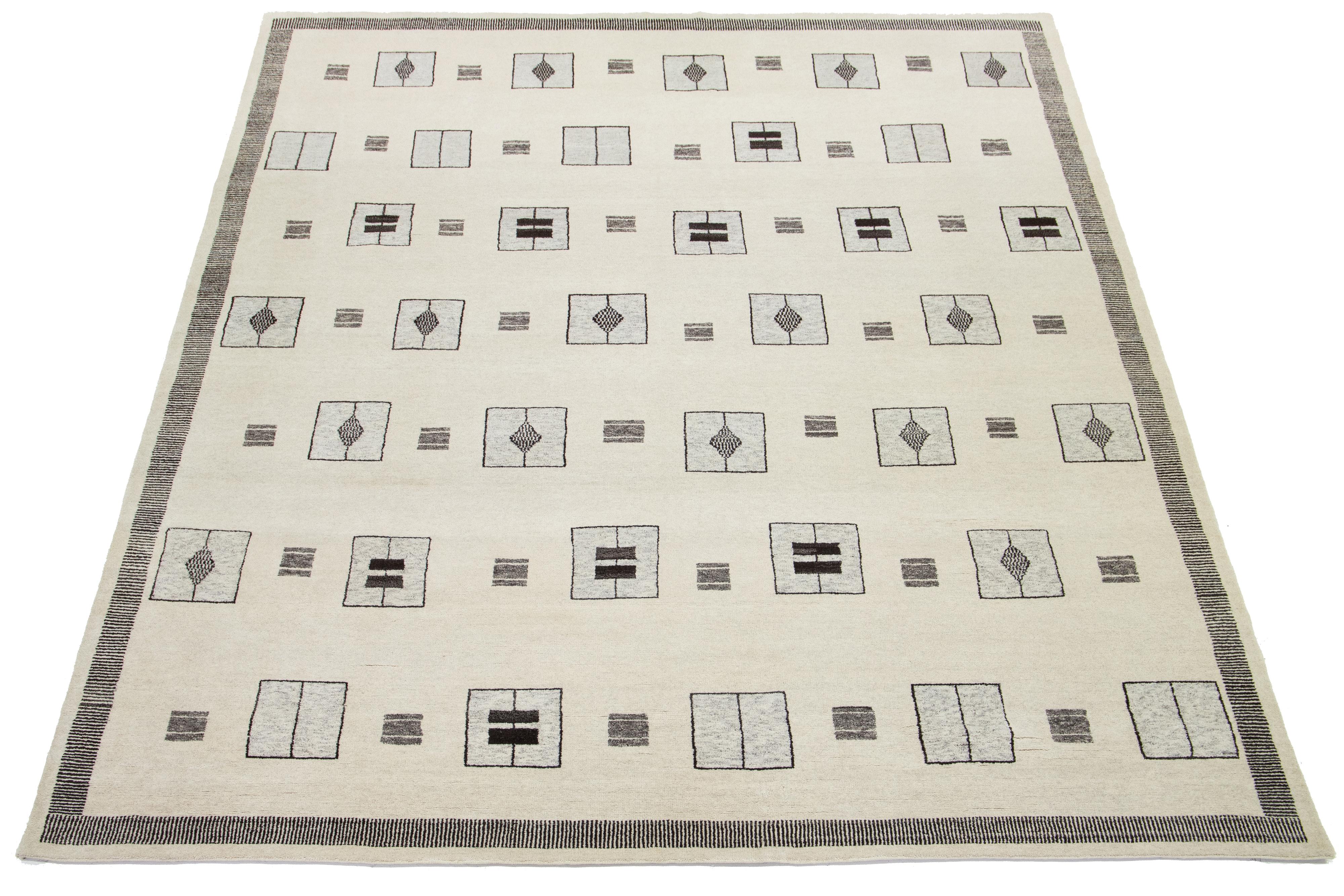 Magnifique tapis moderne de style marocain en laine nouée à la main avec un champ beige naturel. Ce tapis fait partie de la Collection S/One de Apadana et présente un motif géométrique en gris.

Ce tapis mesure 11'10