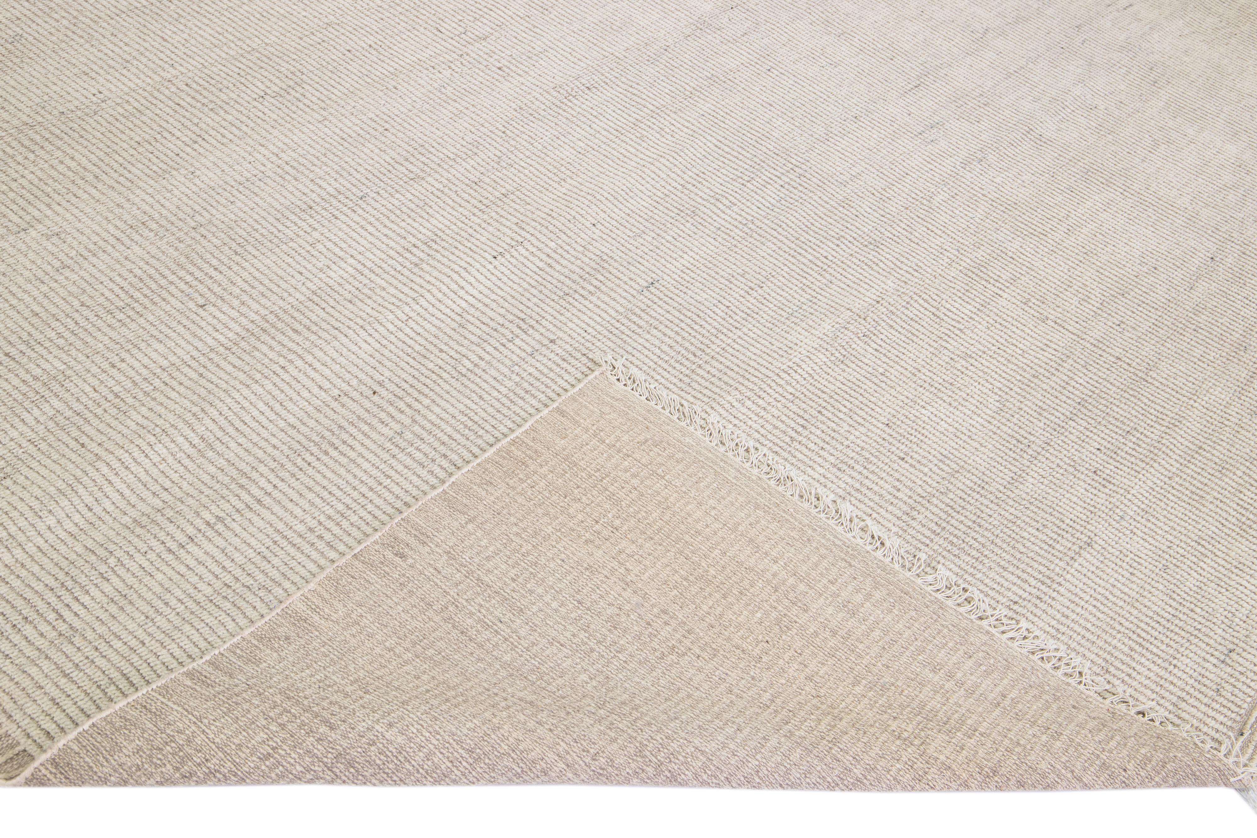 Beautiful modern Moroccan style hand-knotted wool rug with an ivory field and fringes on the top and bottom end of a gorgeous vertical striped design.

This rug measures: 12'2