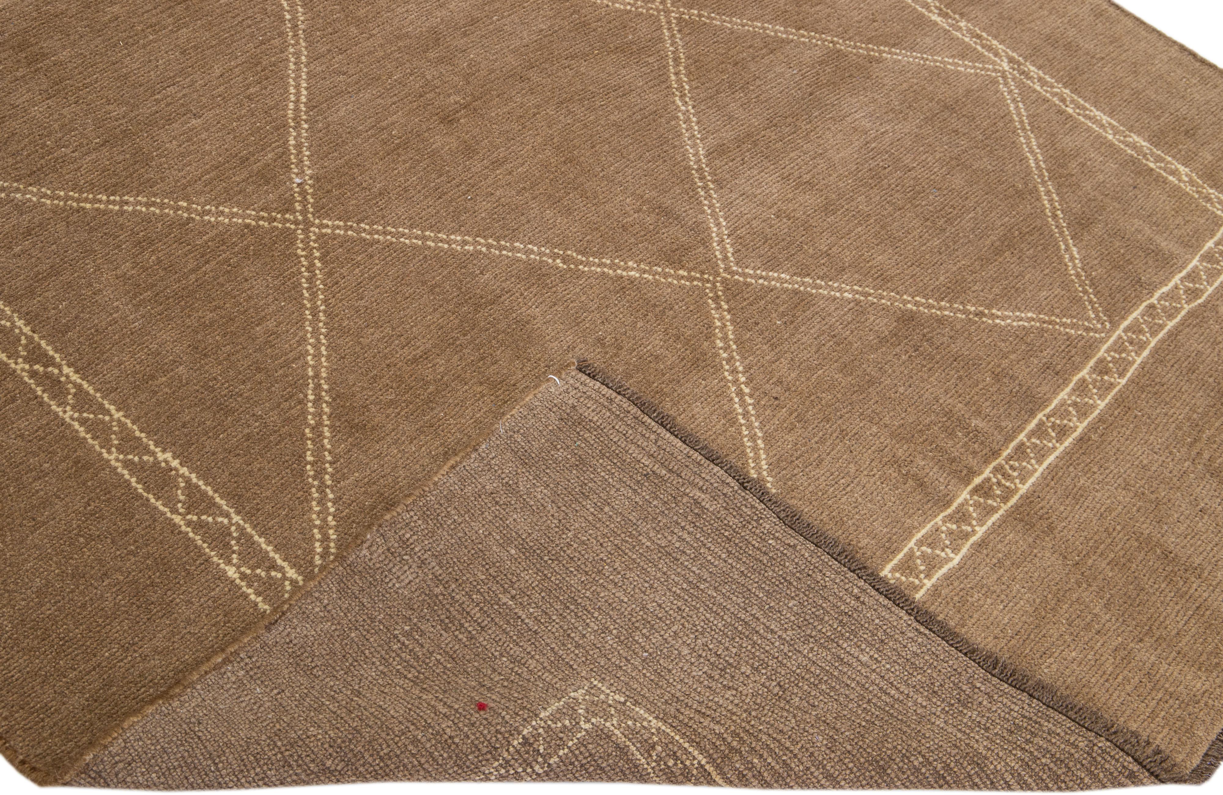 This Beautiful Moroccan-style handmade wool rug makes part of our Northwest collection and features a light brown color field and dark Beige accents in a gorgeous geometric tribal design.

This rug measures: 6'9