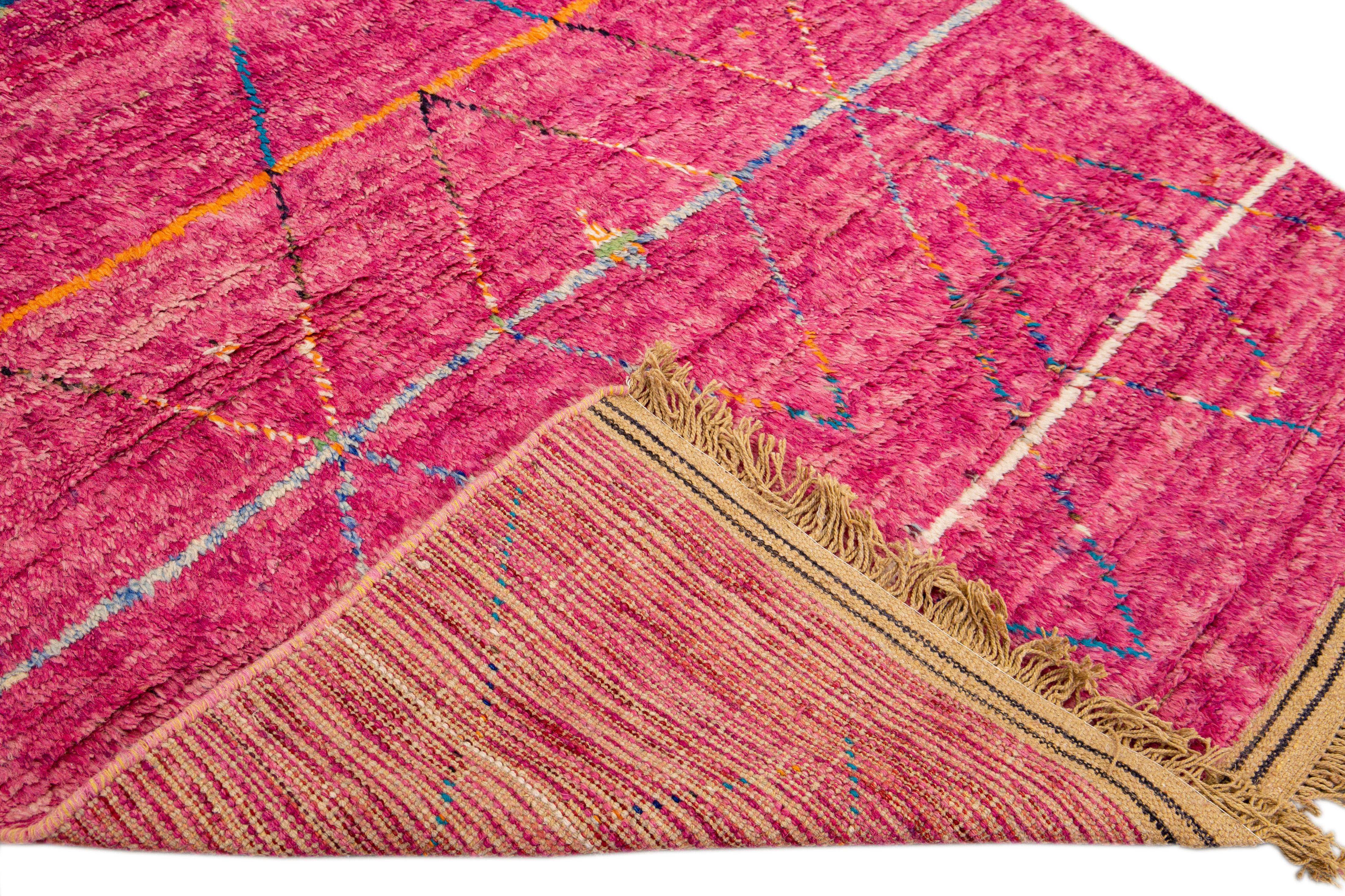 Schöner handgefertigter Wollteppich im marokkanischen Stil mit rosa Feld. Dieser moderne Teppich hat mehrfarbige Akzente und hellbraune Fransen, die ein wunderschönes geometrisches Boho-Stammesmuster zeigen.

Dieser Teppich misst: 6' x
