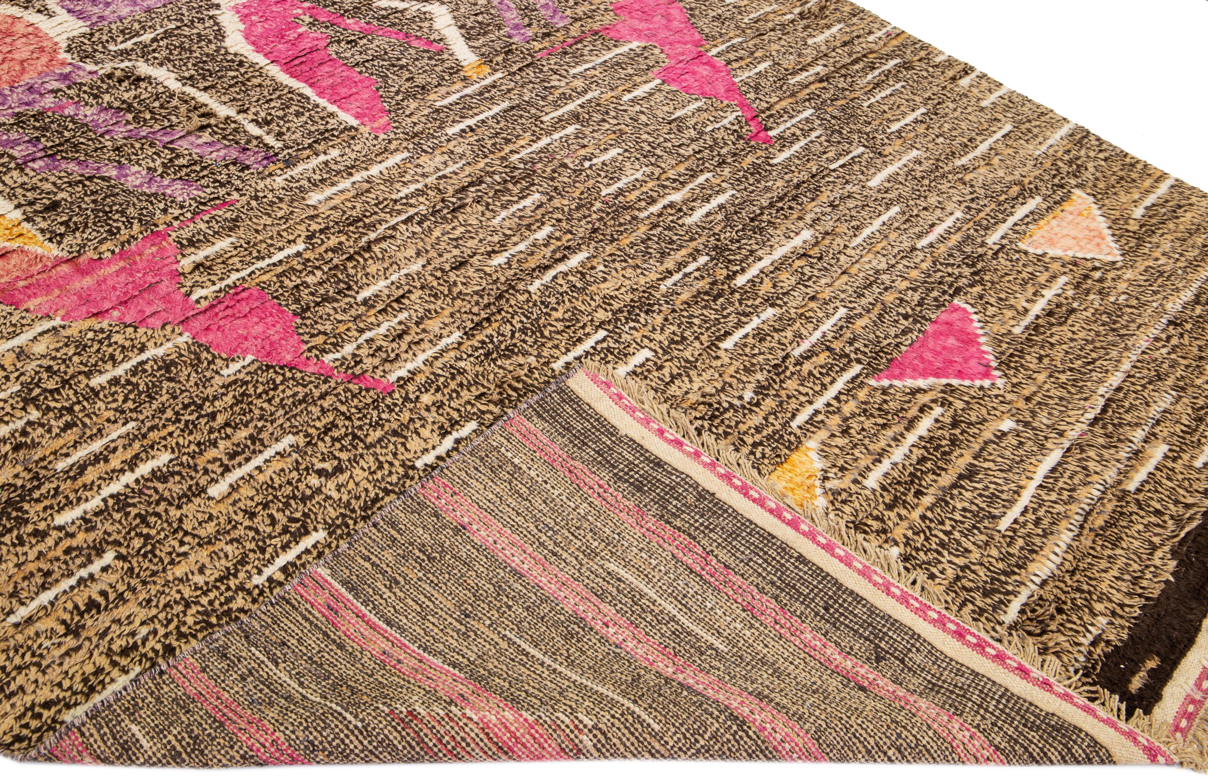 Beautiful modern Moroccan style hand-knotted wool rug with a tan and brown field. This piece has multicolor accent color in a gorgeous Abstract design with fringes on the top and bottom end.

This rug measures: 8'10