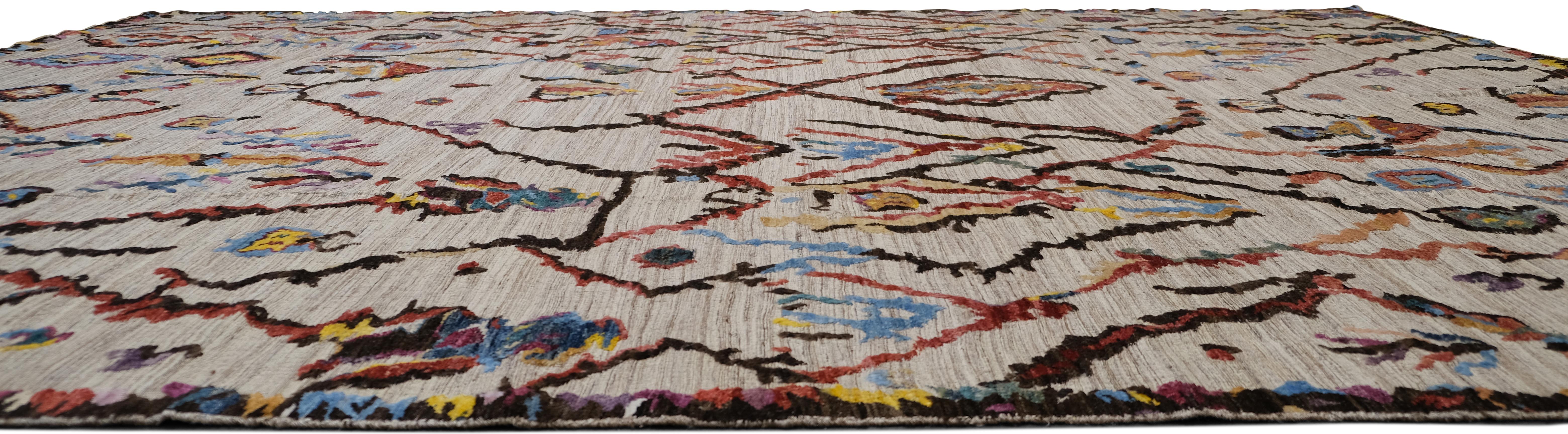 Aporta un estallido de energía y estilo artístico a tu espacio con esta alfombra de lana anudada a mano. Con un diseño abstracto de inspiración tribal, esta alfombra combina colores vibrantes con patrones dinámicos para una estética atrevida y llena