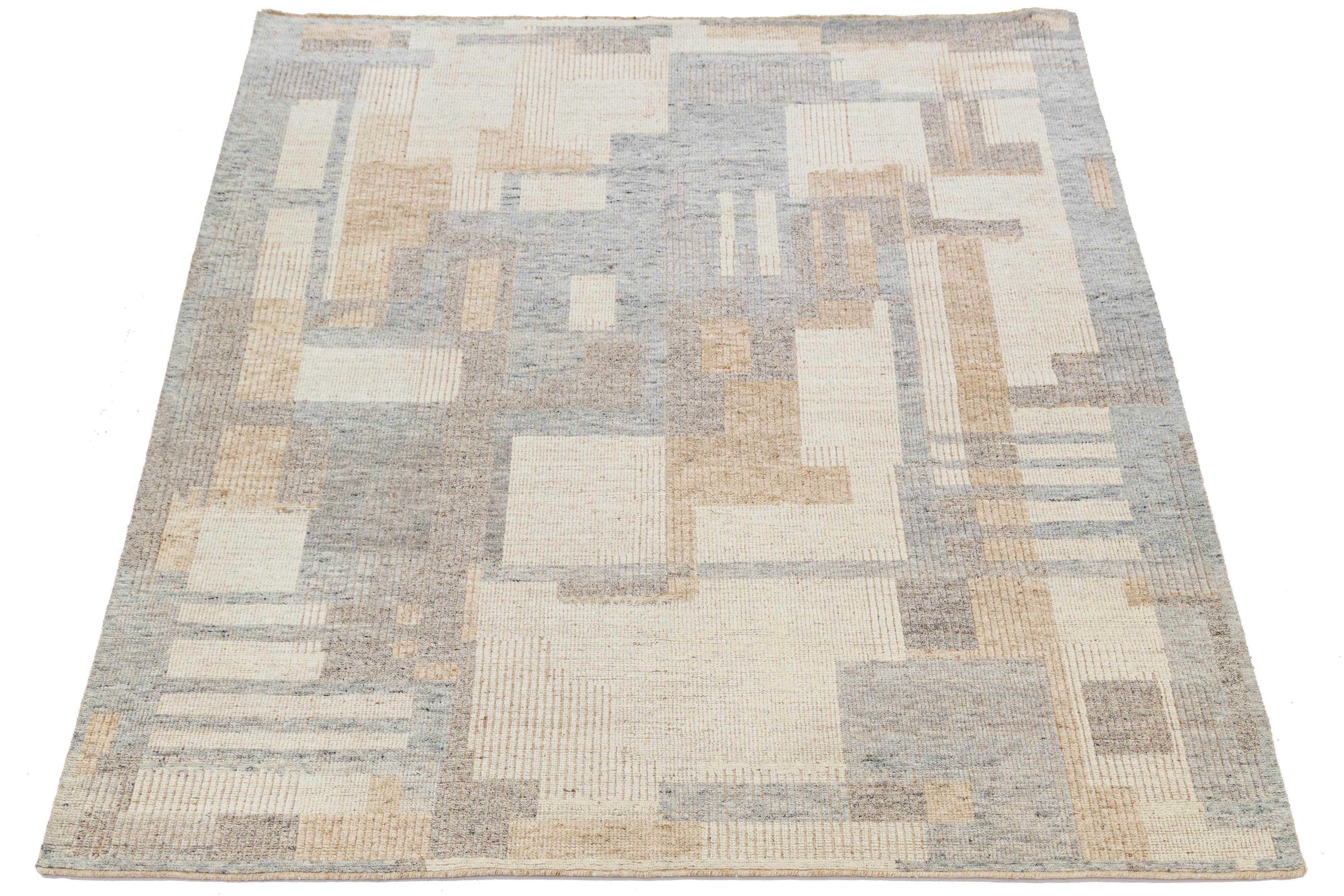 This modern Moroccan-style wool rug features a sophisticated patchwork of abstract rectangles in muted beige, cream, and taupe tones. Handwoven with subtle texture and geometric rhythm, it offers a refined minimalist aesthetic ideal for curated