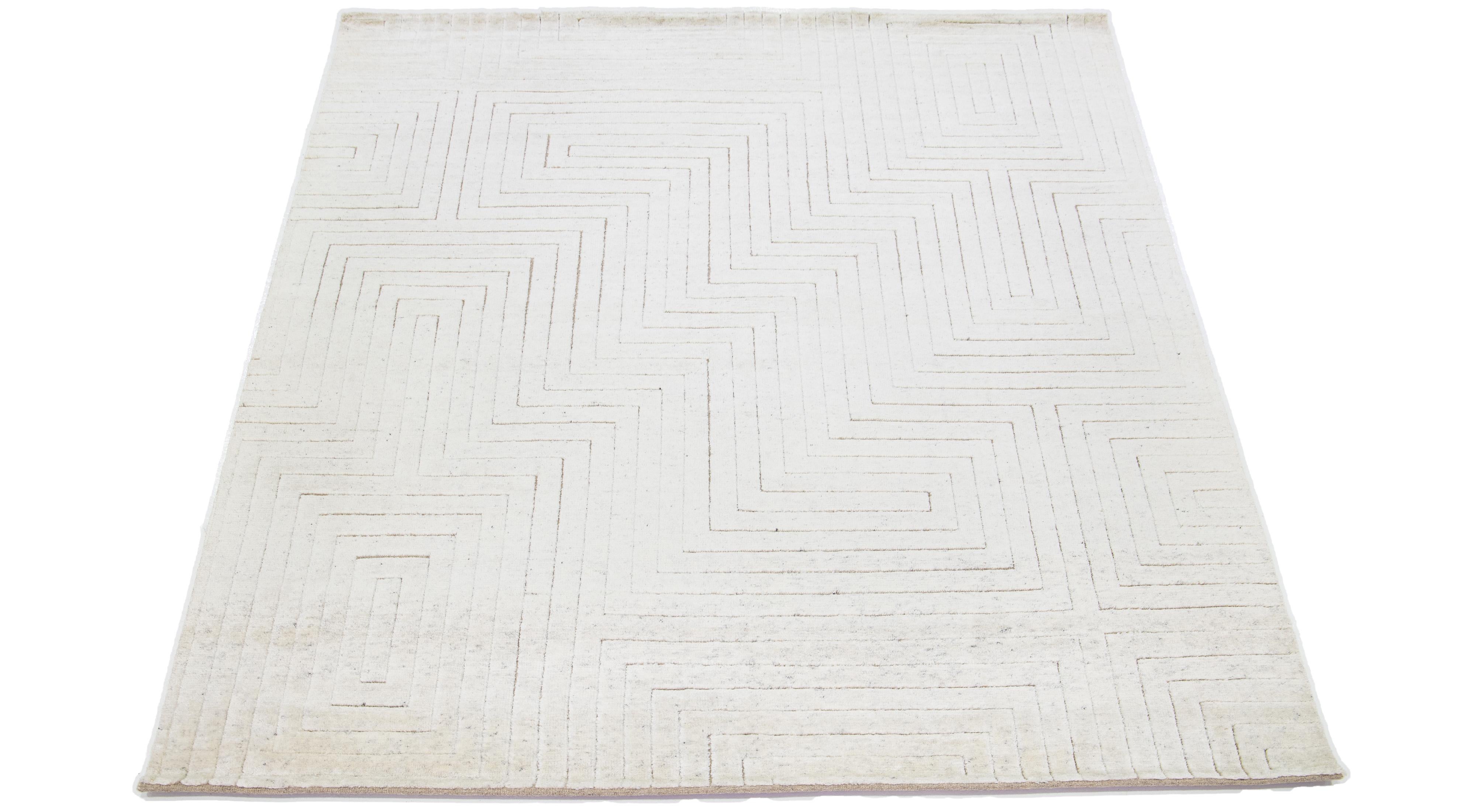 Featuring a contemporary Moroccan-inspired design, this hand-knotted wool rug is accentuated by subtle ivory tones atop a striking ivory base—a stunning geometric Seamless pattern.

This rug measures 8'1