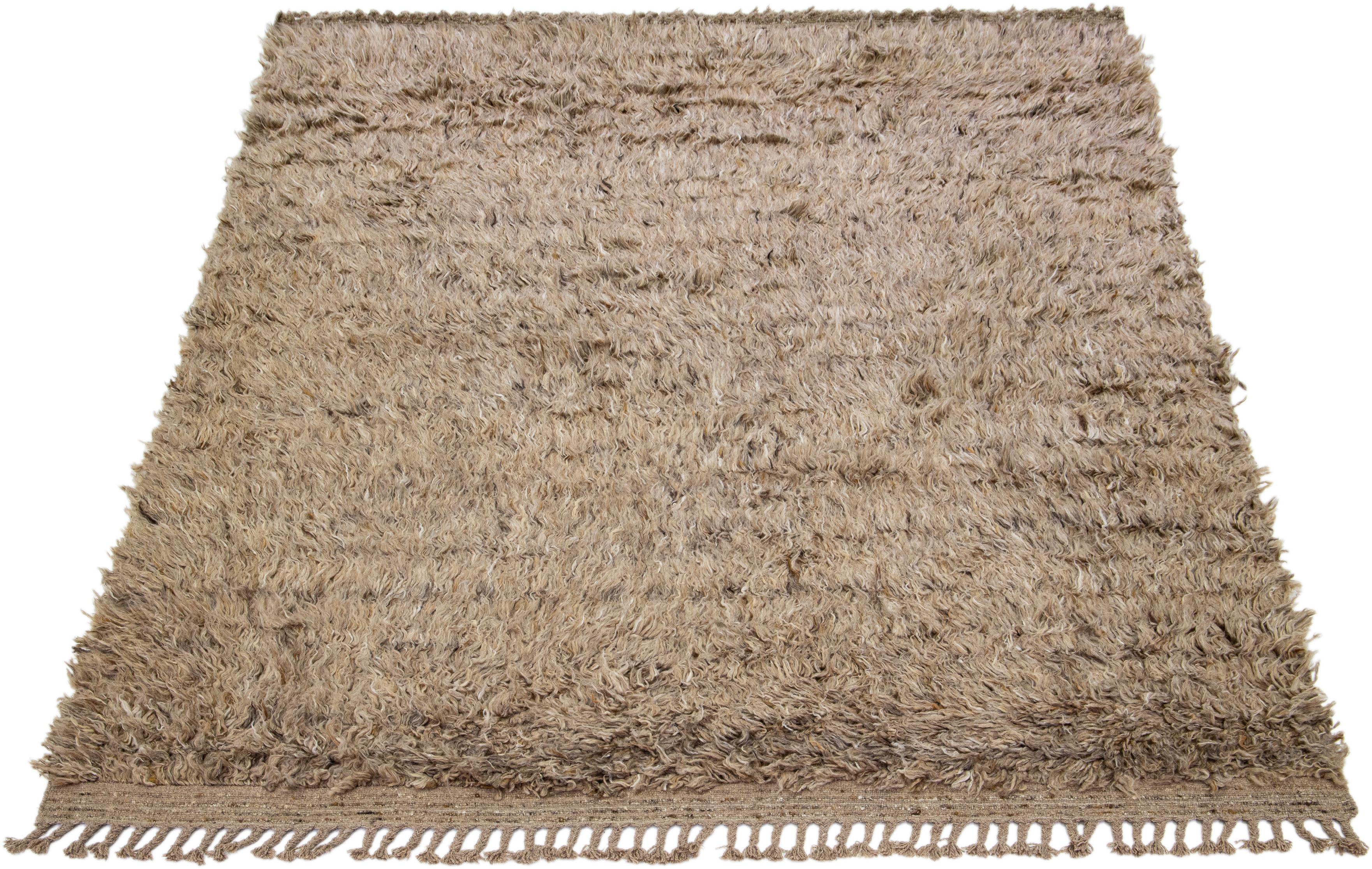 This hand-knotted organic wool rug features a contemporary Moroccan style. This piece has a captivating solid brown background. 

This rug measures 8'3' x 10'3