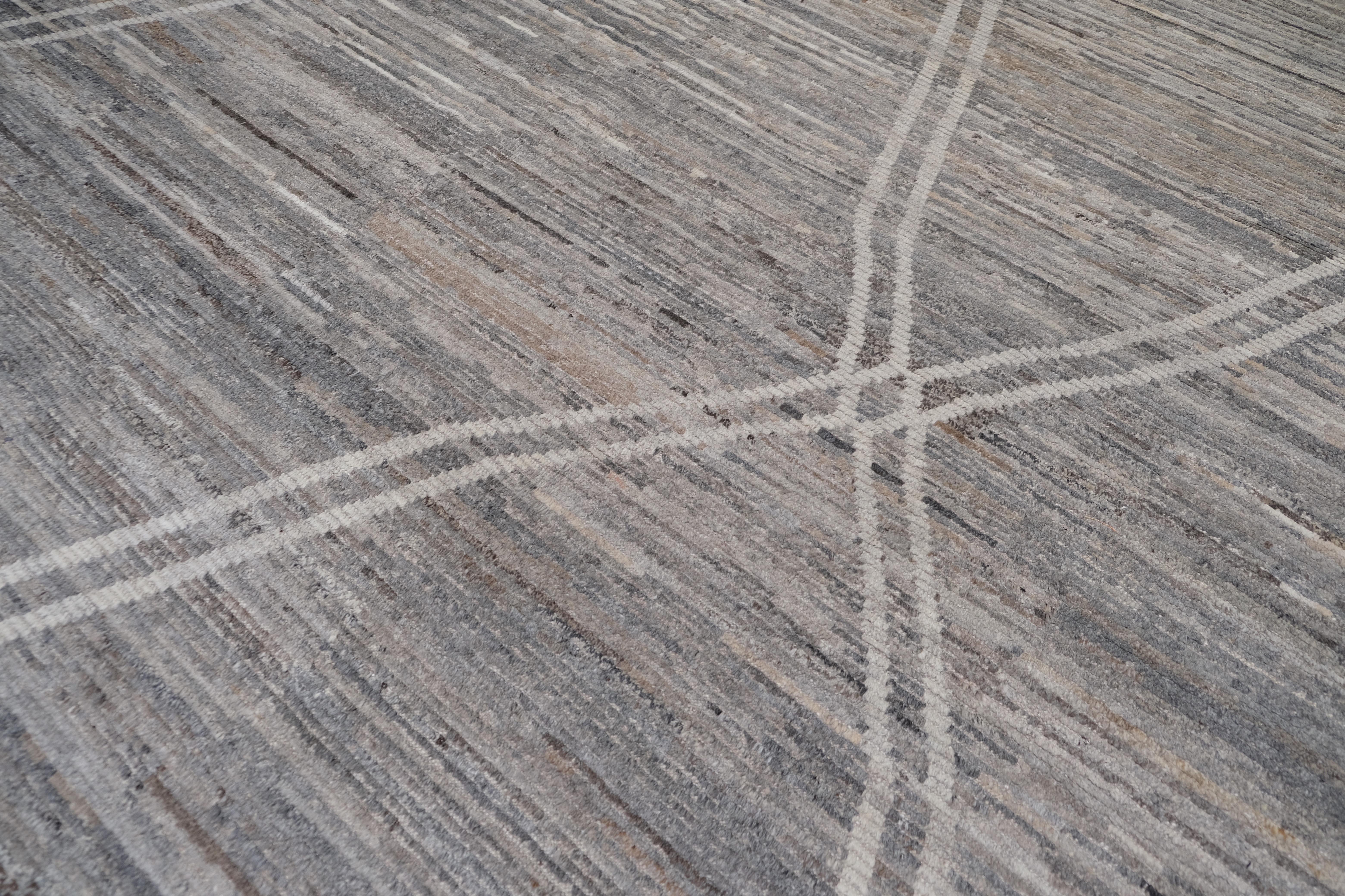 This hand-knotted wool rug from Afghanistan is a masterful blend of contemporary design and traditional craftsmanship. Measuring approximately 14' x 15', this rug features an organic linear pattern in subtle gray and ivory tones, creating an
