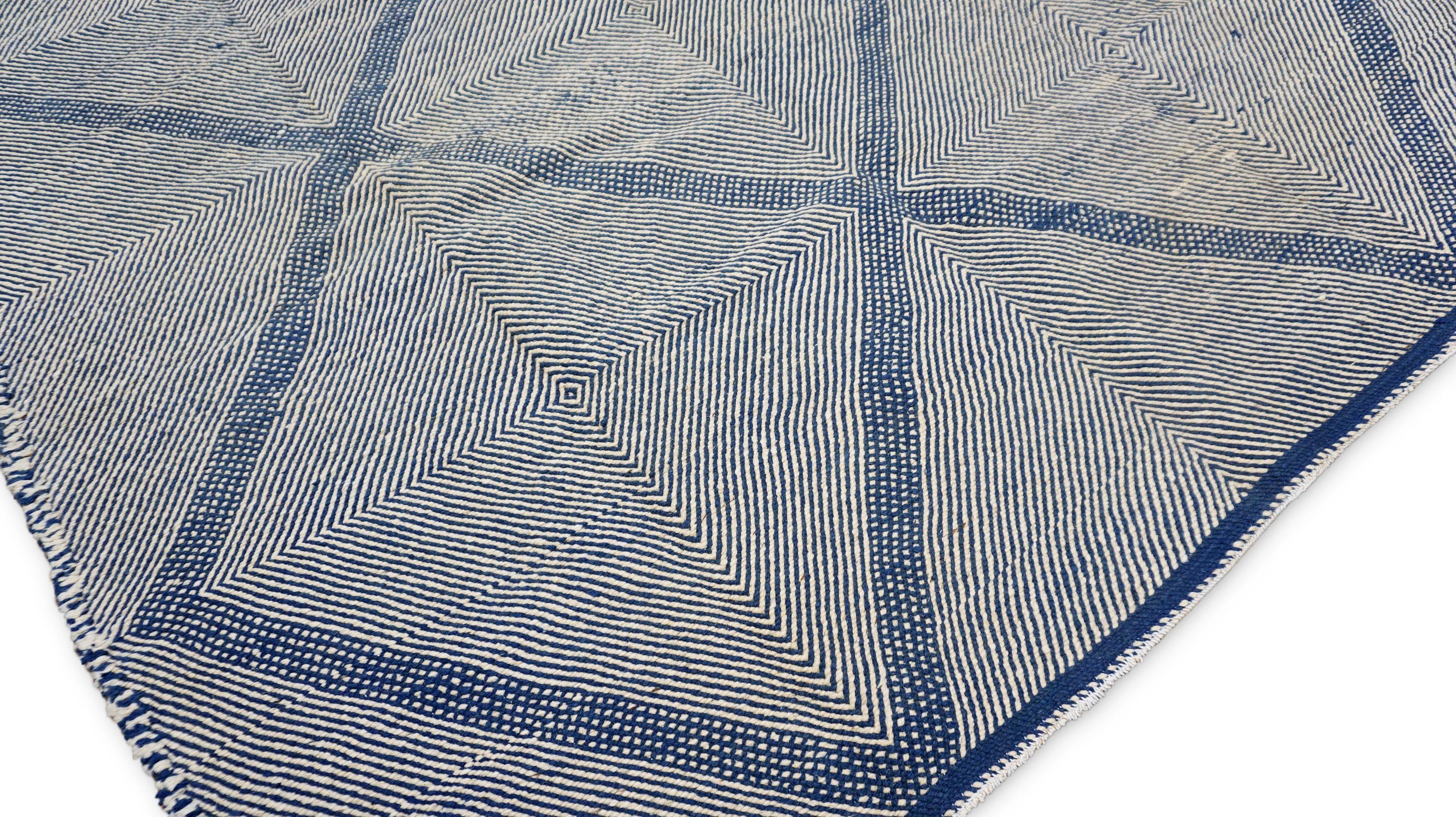 Ce tapis en laine noué à la main présente un motif géométrique captivant qui allie parfaitement l'artisanat traditionnel au minimalisme moderne. Méticuleusement fabriqué par des artisans qualifiés, le tapis présente une série de motifs de diamants