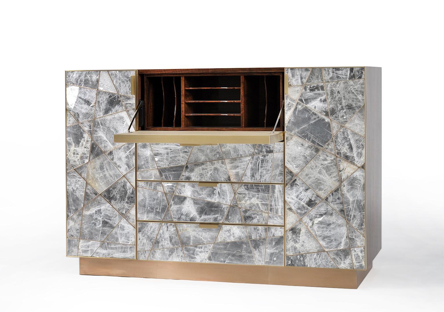 The Mosaic cabinet in selenite, bronze and claro walnut is a strikingly opulent example of a few of the most beautiful materials in the natural world that we have been given as furniture makers to work with. 
The geometric pieces of selenite are