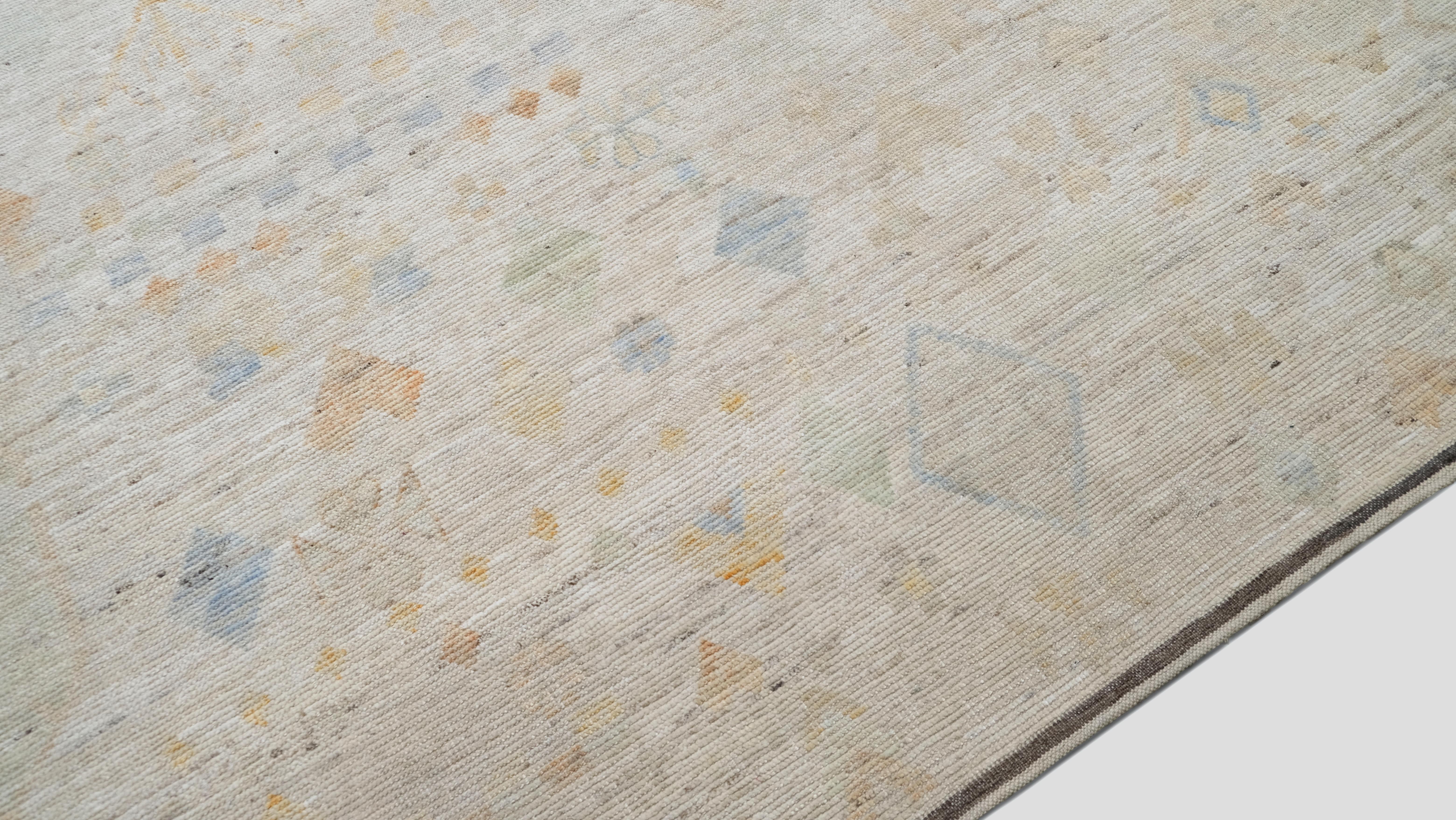 Apportez une élégance discrète à votre espace avec ce tapis en laine noué à la main, qui présente un magnifique design tribal. Cette pièce exquise présente des motifs géométriques et floraux complexes dans de douces teintes pastel de jaune, de bleu,