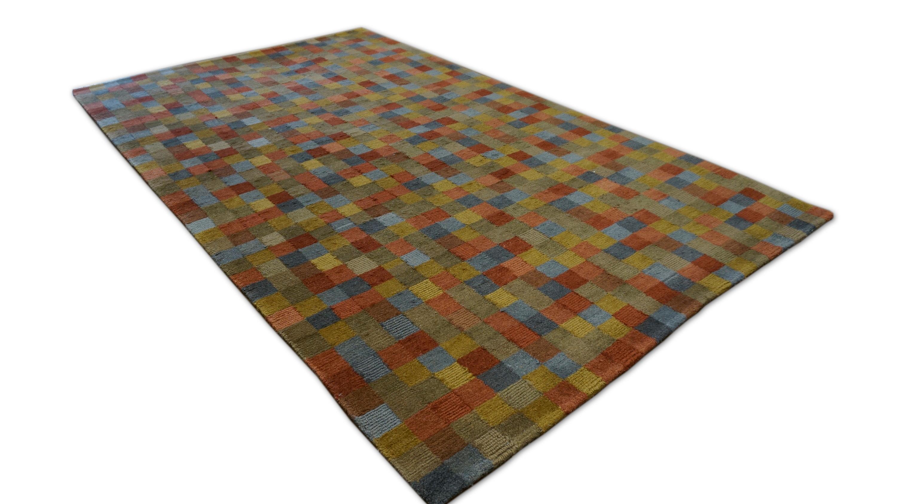 Ce tapis contemporain en laine nouée à la main présente une réinterprétation audacieuse et ludique du design géométrique à travers un motif en damier pixellisé et vibrant. Le tapis est fabriqué à la main à partir de laine filée à la main, ce qui