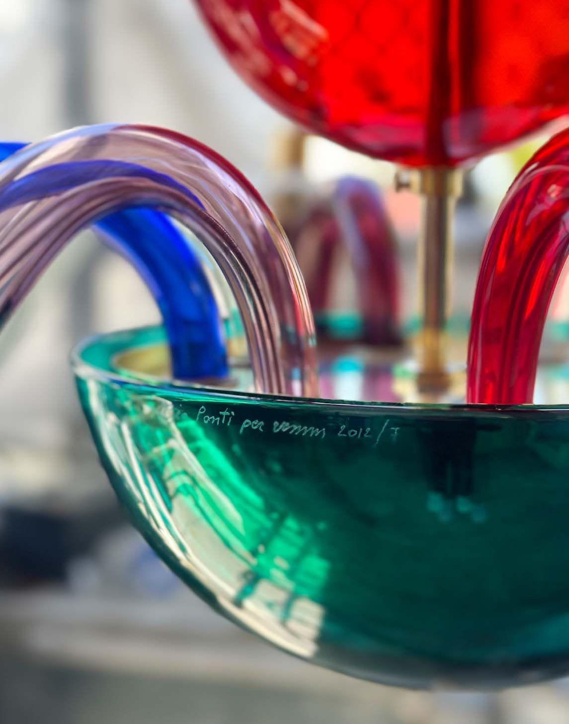 Un sorprendente lampadario moderno italiano in vetro di Murano e ottone, originariamente progettato da Gio Ponti per Venini nel 1946 e magistralmente rieditato nel 2012. Questo pezzo eccezionale presenta un globo centrale semicircolare con due sfere