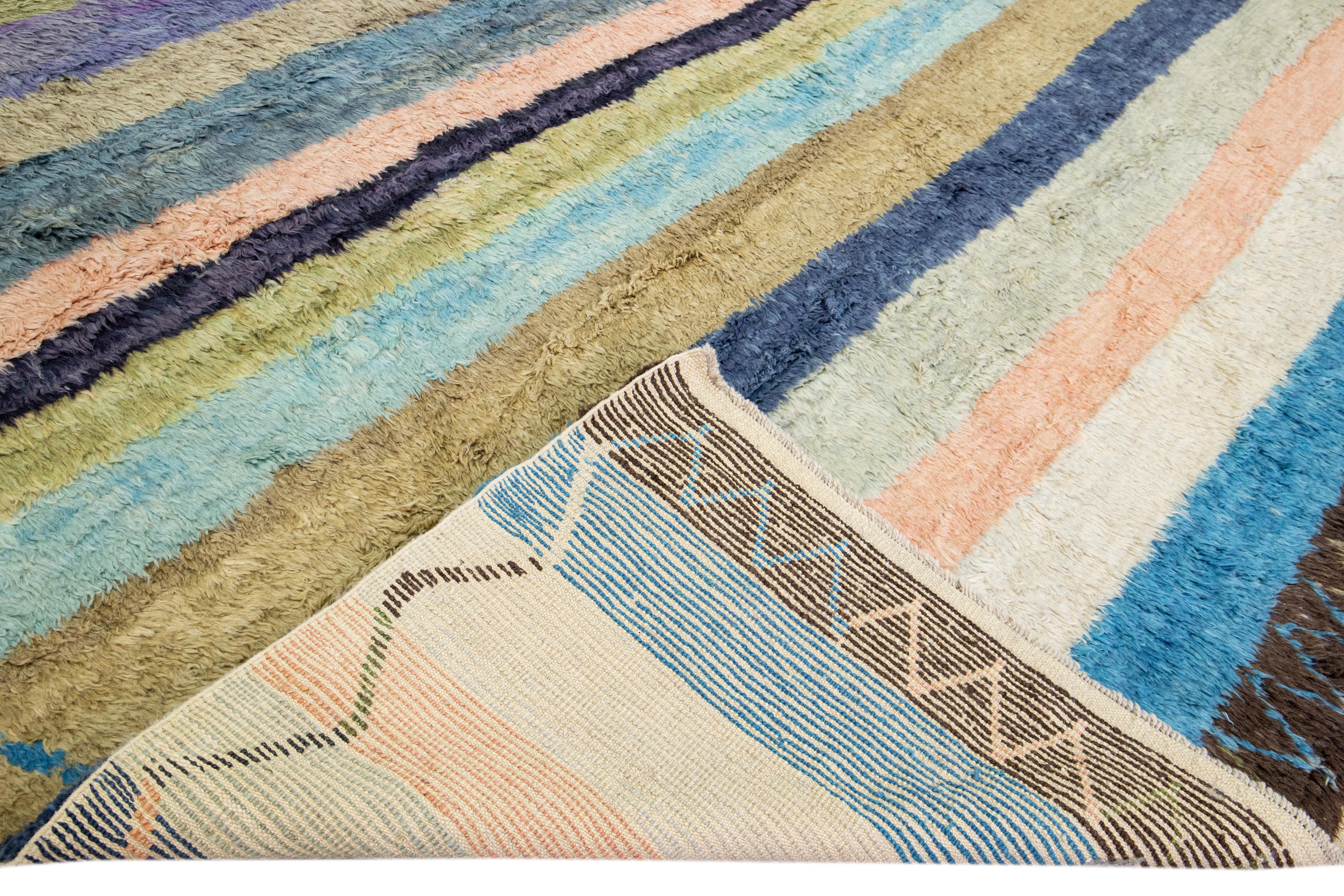 Beautiful modern Tulu hand-knotted wool rug with a multicolor field. This Tulu rug has a geometric frame with a gorgeous all-over striped design. 

This rug measures: 13'1