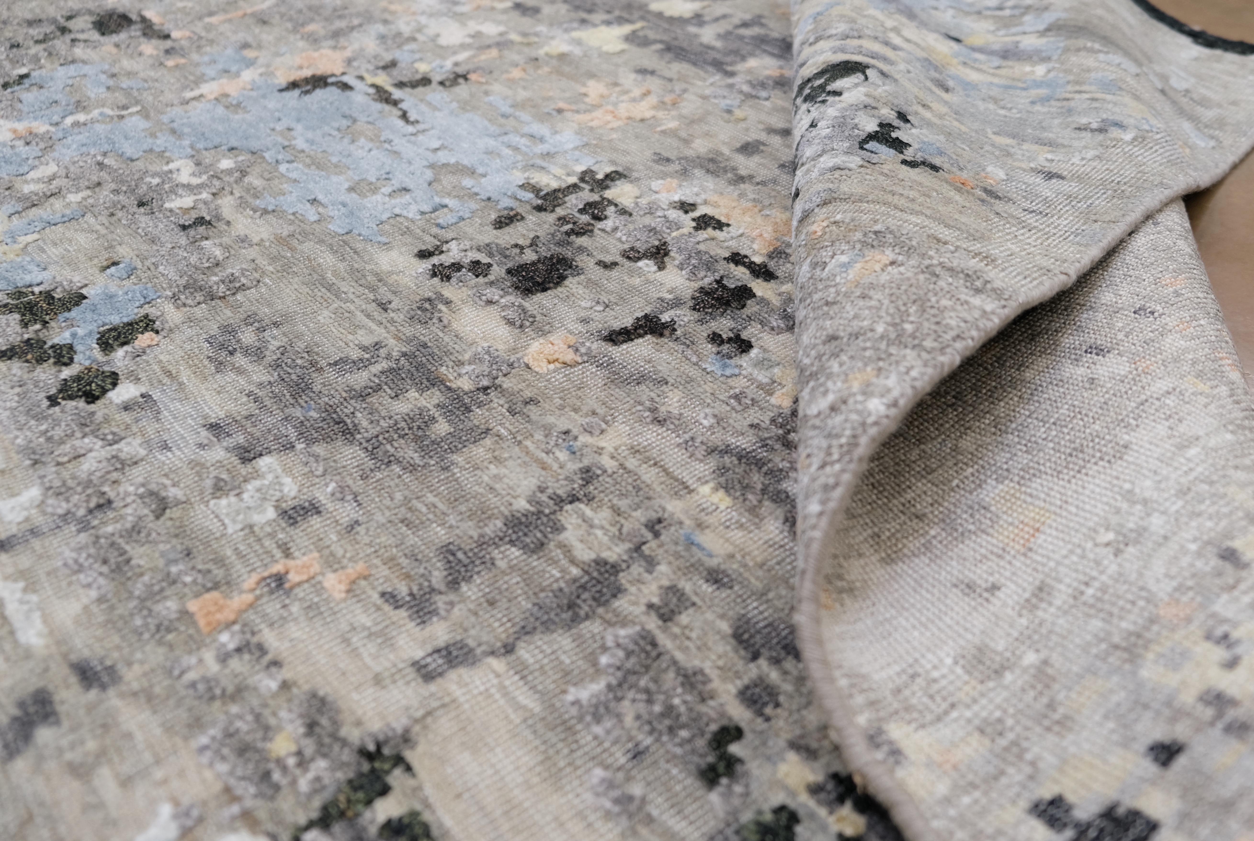 Transformez votre espace avec l'art saisissant de ce tapis noué à la main, fabriqué de manière experte en Inde à partir d'un luxueux mélange de laine et de bambou. Doté d'un design abstrait multicolore avec des nuances dynamiques de noir, de gris,