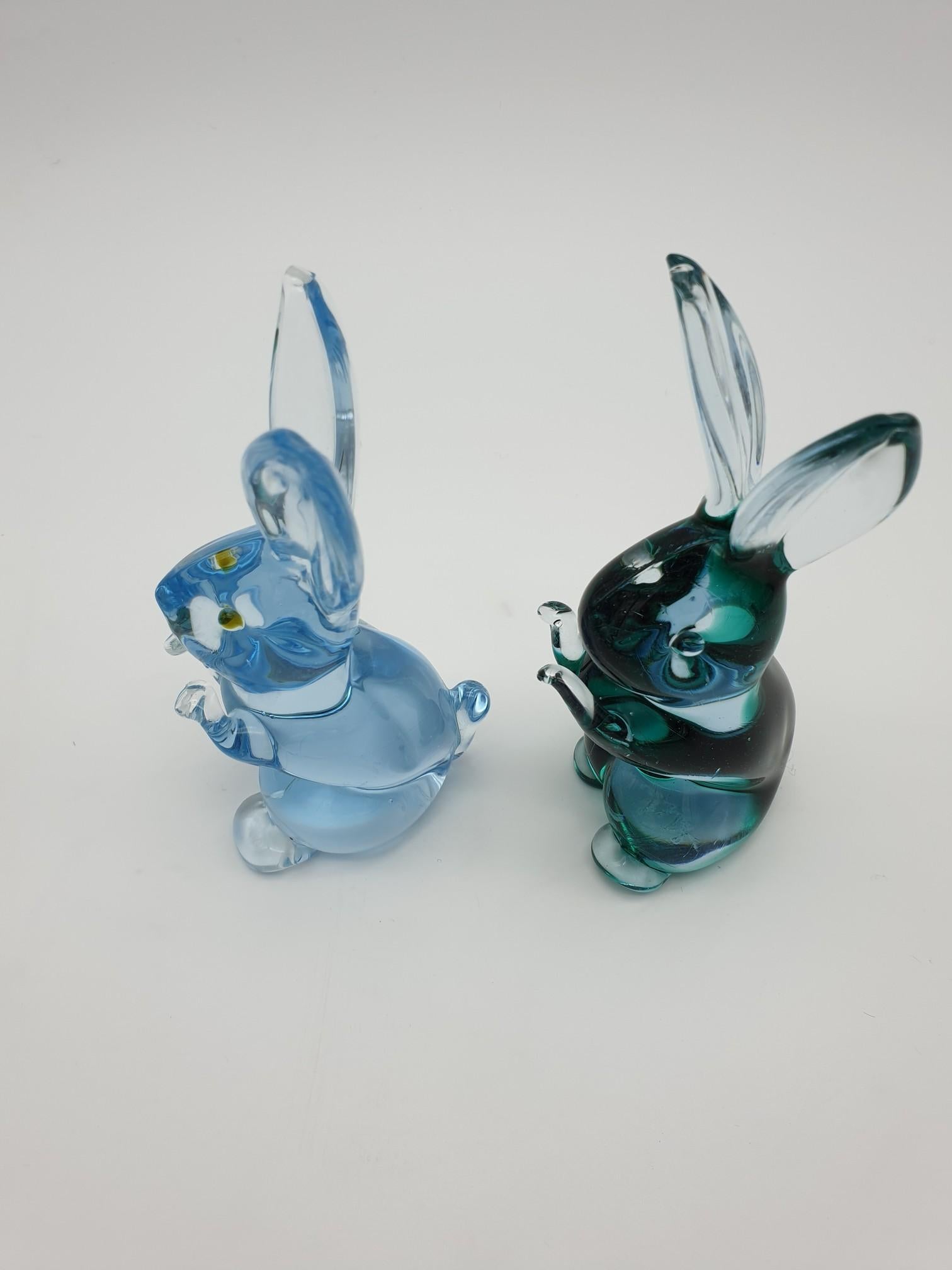 Pair of small Murano glass bunnies, manufactured at the famous glass-factory Gino Cenedese e Figlio during the 1980s. These glass bunnies have been completely handmade, in clear glass with splashes of green and light blue color. These wonderful