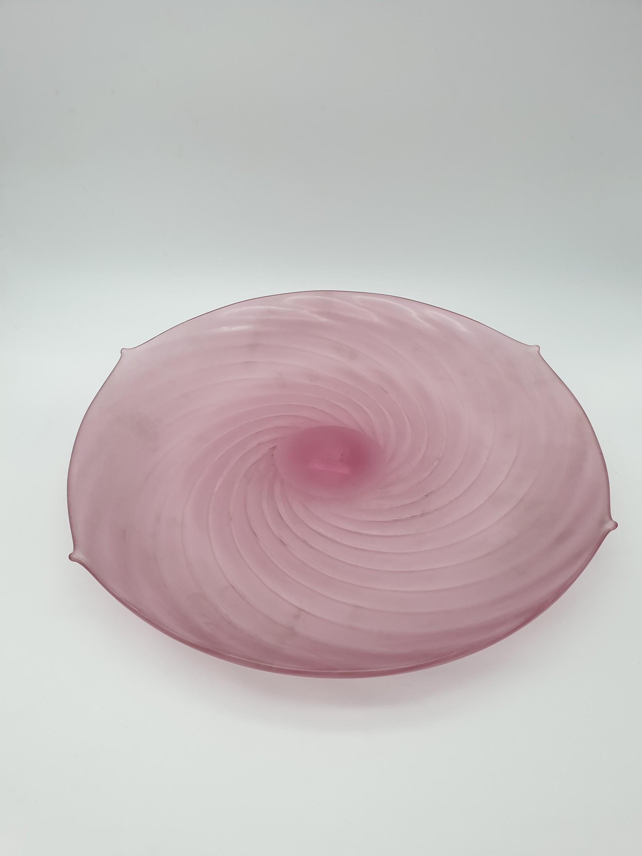 This beautiful modern Murano glass centerpiece (dish) has been completely handmade by Gino Cenedese e Figlio glass factory in the late 1980s. This stunning piece features a delicate ruby pink color and ridged pattern, with four characteristic