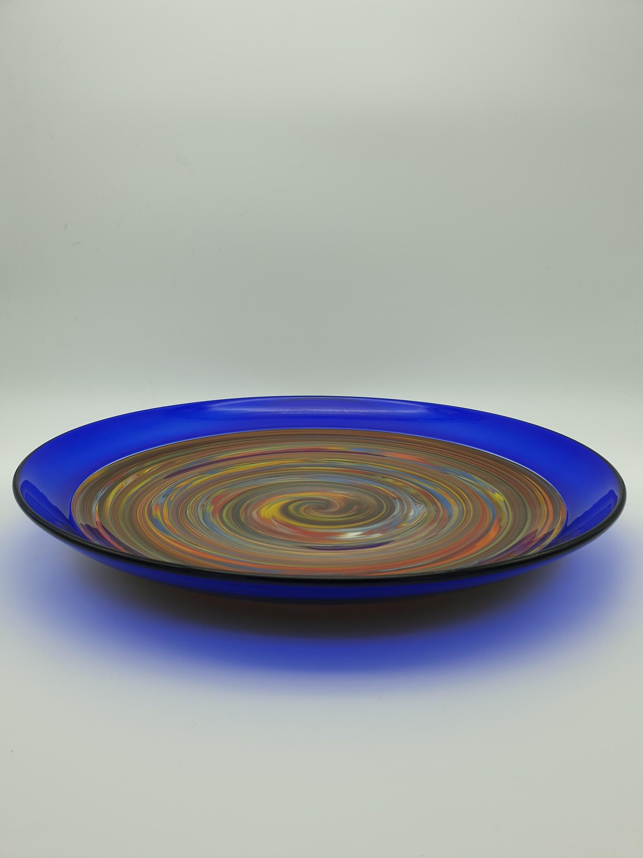 This modern stylish centerpiece / dish / platter by Gino Cenedese e Figlio has been handmade in Murano in the late 1990s. The beautiful central multi-color rainbow has been obtained by swirling glass canes of different color while hot-working the