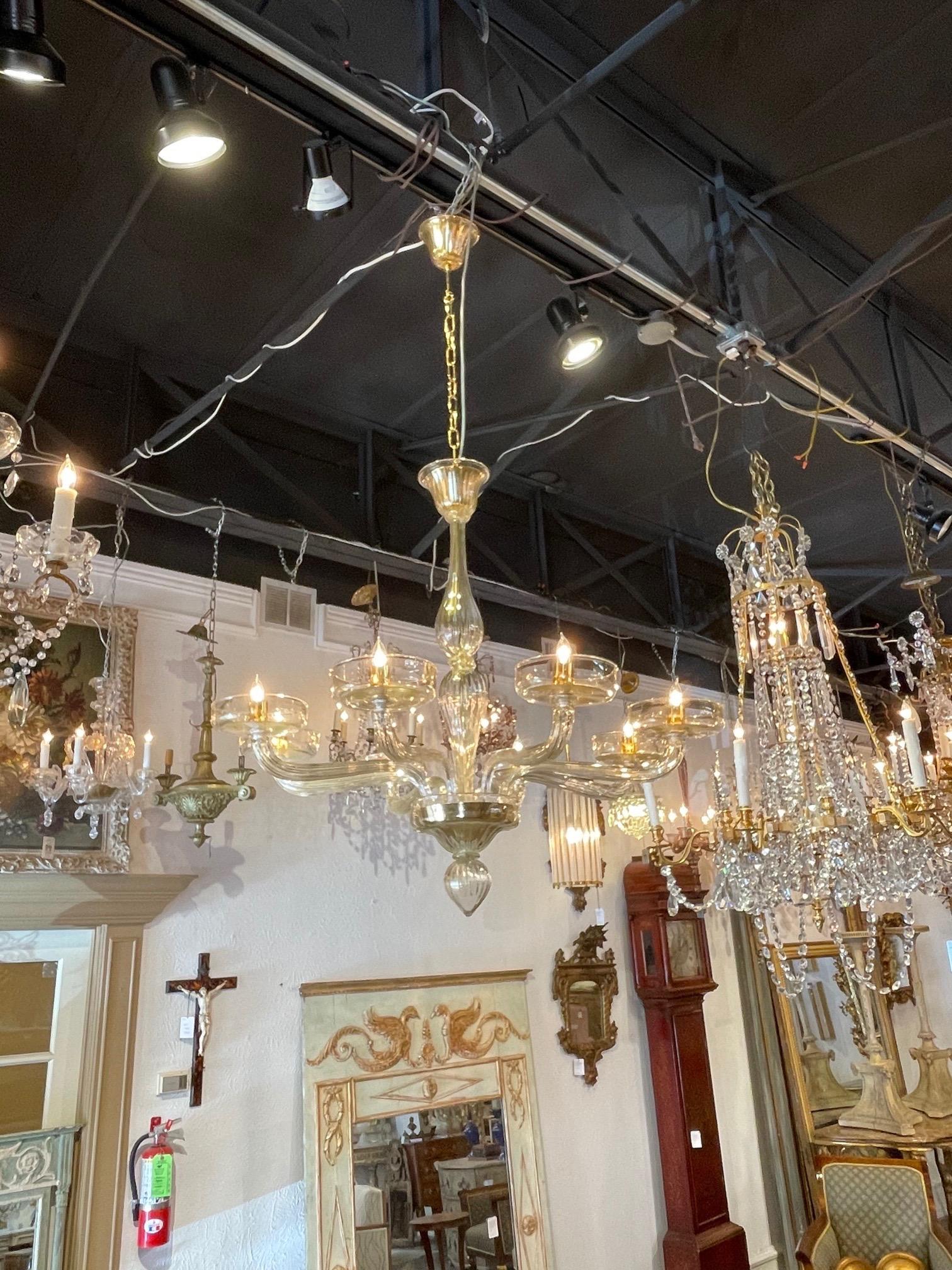 Exquisite pair of gold modern Murano glass chandeliers with 8 arms. Beautiful glistening look and clean lines. Absolutely stunning for a variety of decors!! Note: Price listed is per item.
