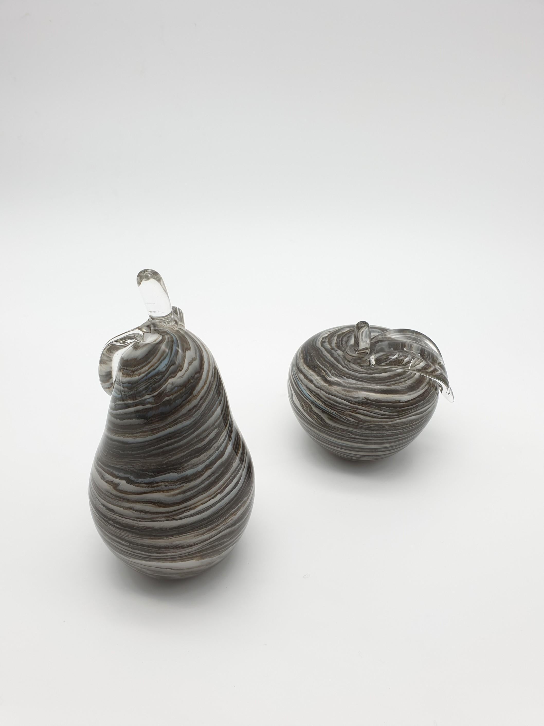 Cool glass apple and pear pair, manufactured by Gino Cenedese e Figlio. These Murano glass ornaments have been handmade by Gino Cenedese e Figlio swirling different shades of color to get cool gray hues in a marbled effect. The apple and pear can