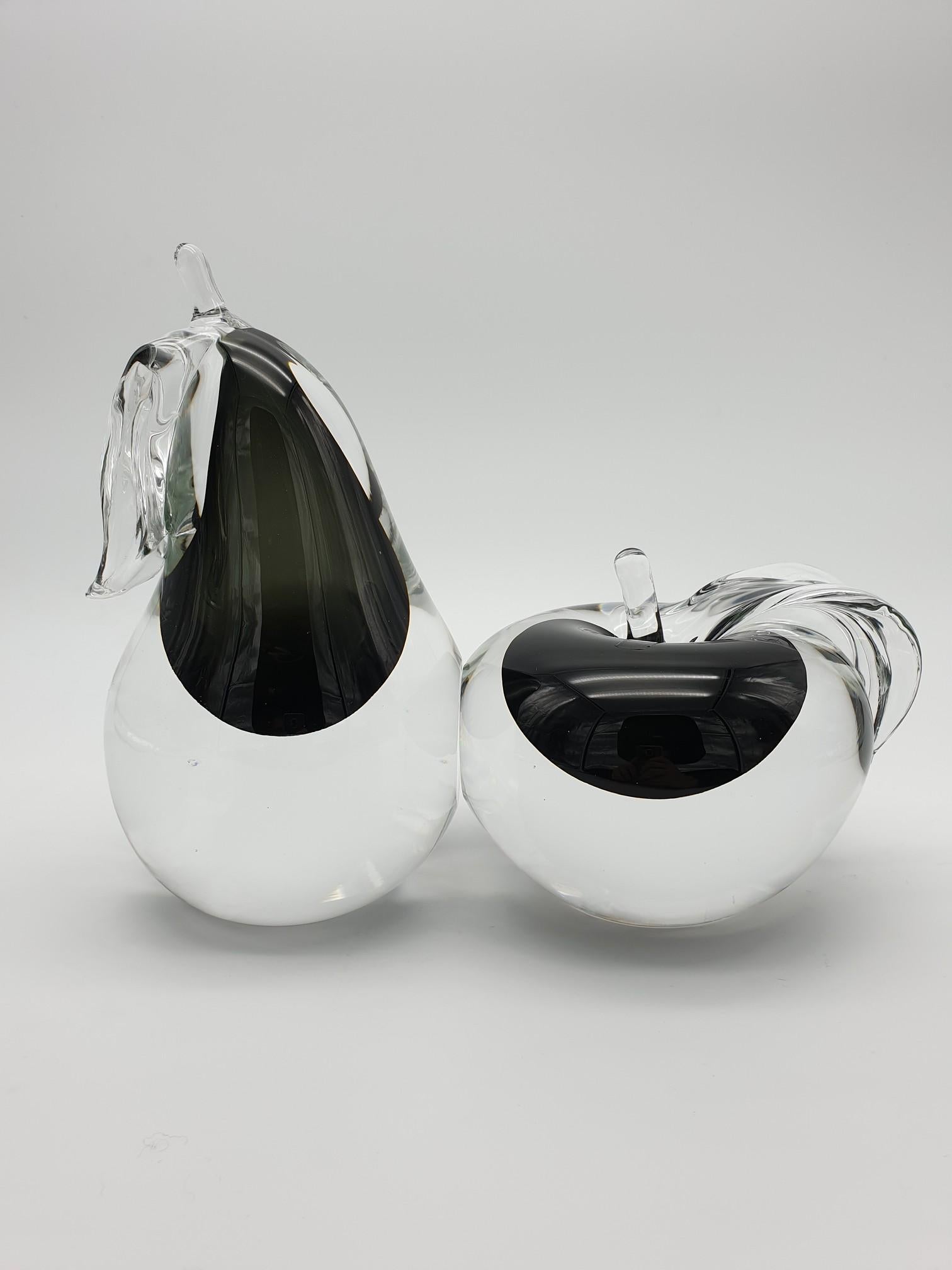Modern Murano glass apple and pear pair, handmade in the 1980s in the island of Murano by the historical glass-factory Gino Cenedese e Figlio. This elegant set is made of apple and pear in clear glass with a black 